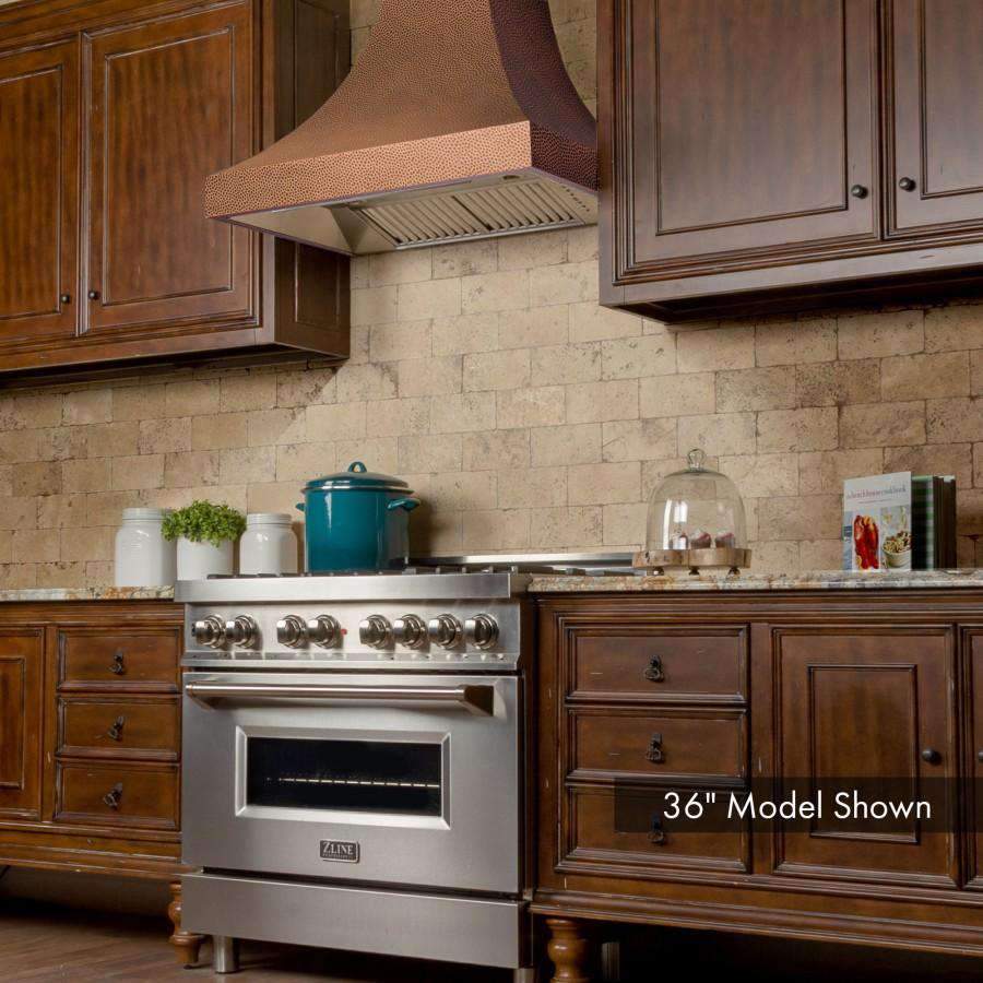 Copper hammered-finish wall range hood over stainless cooking hood insert and vents