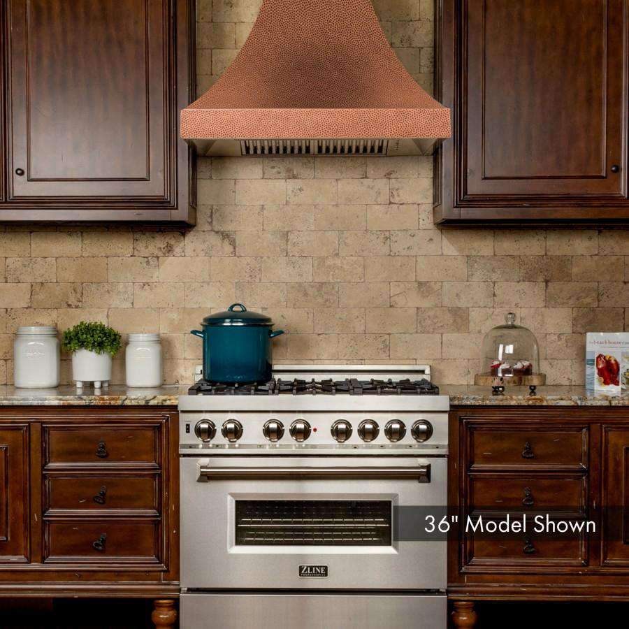 Copper hammered-finish wall range hood with stainless vent grille and chimney duct