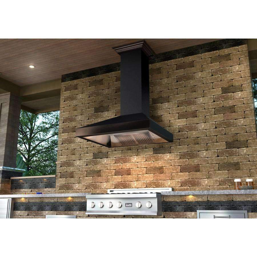 Designer wall range hood with matte black chimney centered on stone outdoor kitchen wall
