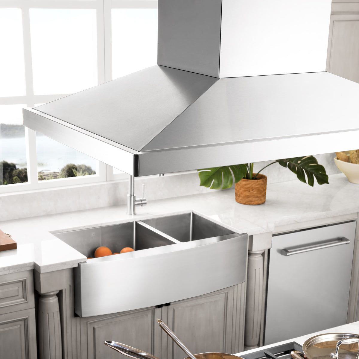 Stainless steel island mount range hood with wide chimney and vented canopy over cooktop