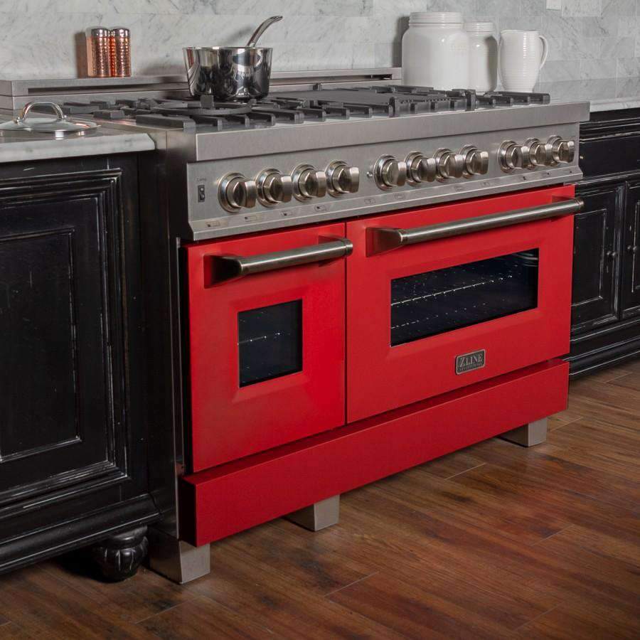 Front three-quarter view of dual fuel range with stainless top, red doors, and knobs