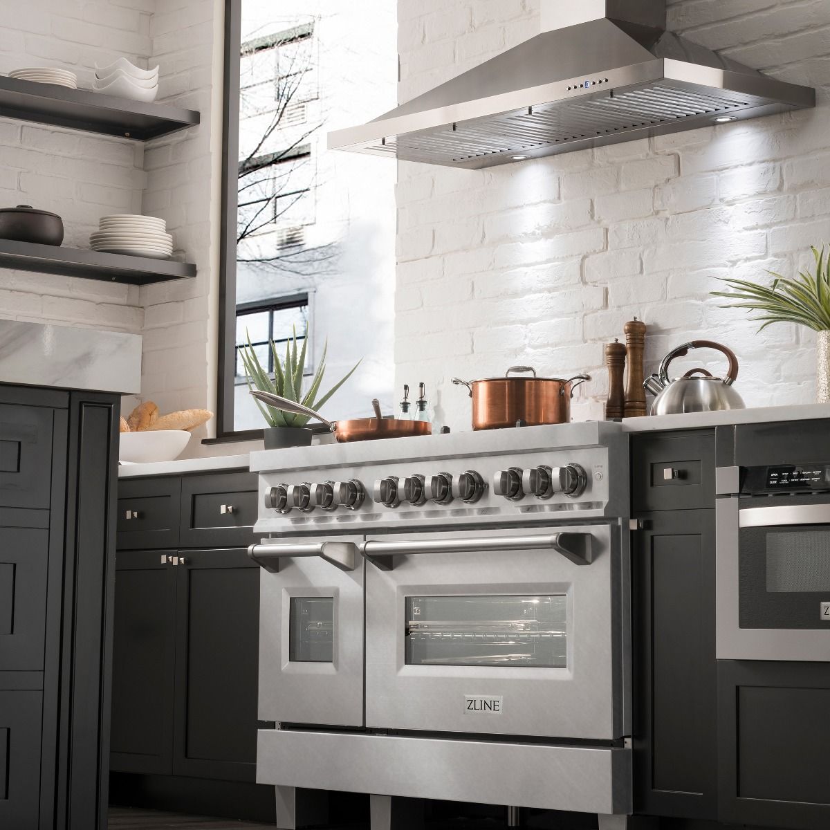 Stainless steel dual fuel range with control knobs, griddle hood vent, and two oven doors