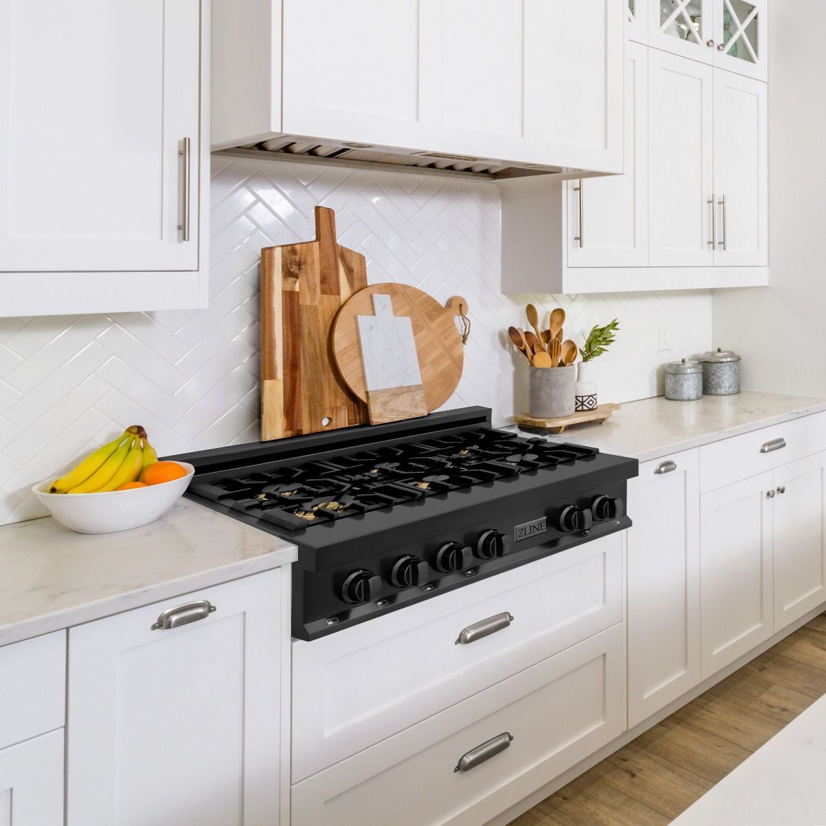 Black gas rangetop in a kitchen with open burners and metal control knobs