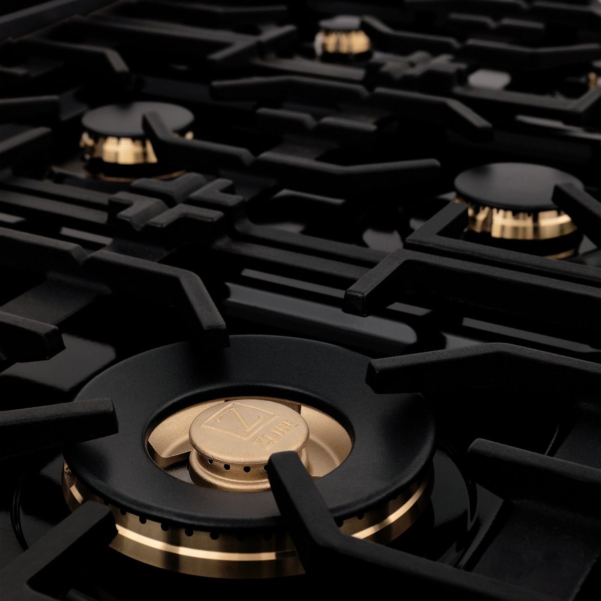 Black gas cooktop burner with ZLINE-branded brass cap and circular burner ring