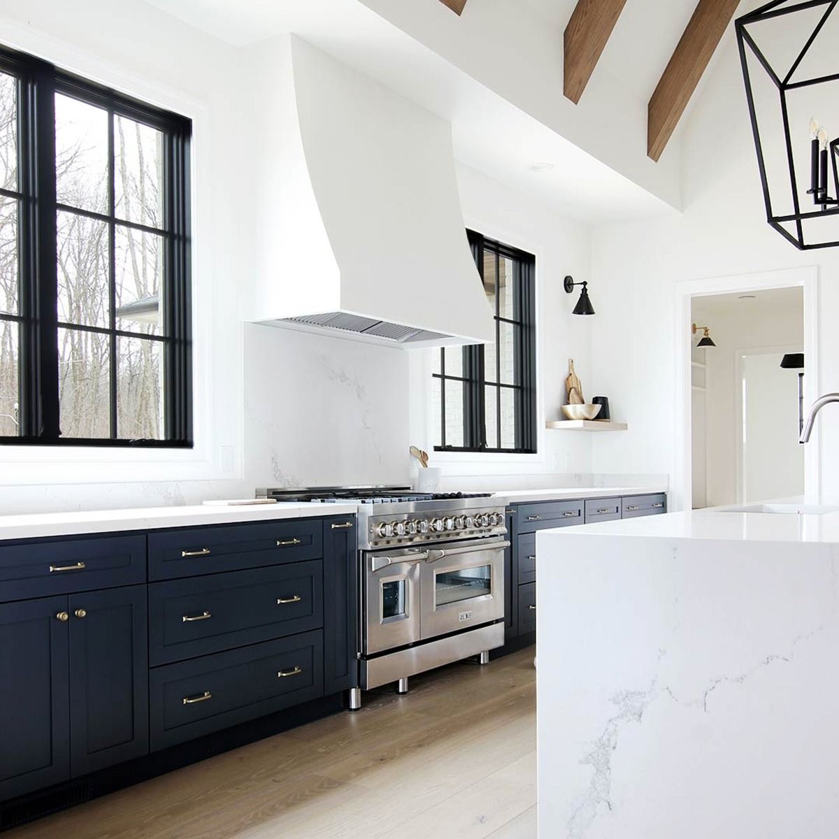 Stainless steel range hood insert installed above a cooktop in a kitchen