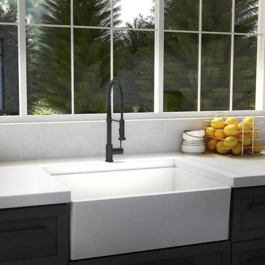 Matte black kitchen faucet with high arched spout over white sink.