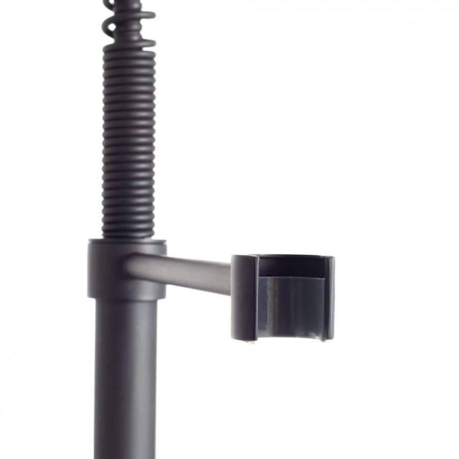 Matte black faucet diverter control on base with connection to coiled sprayer hose