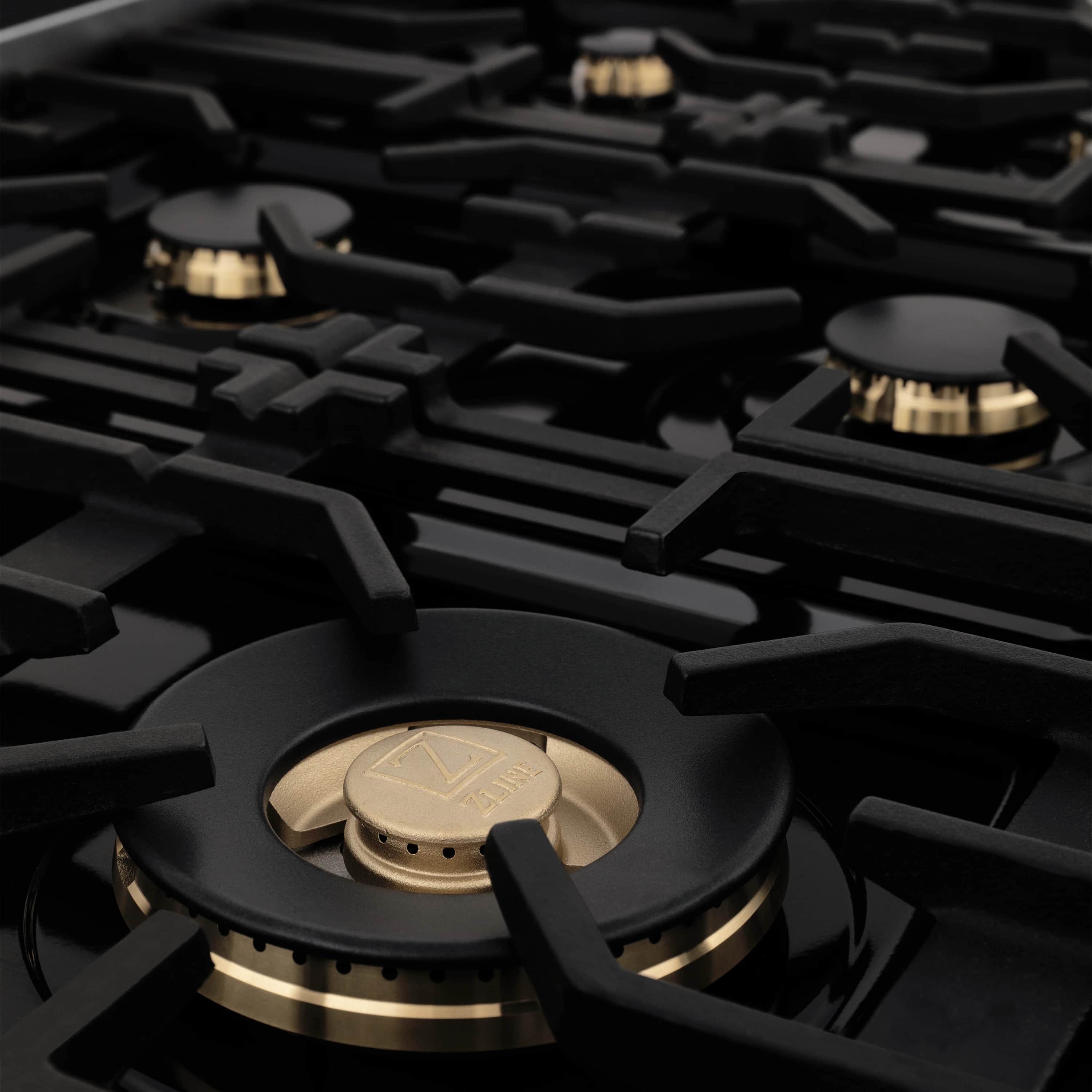 Gas range burner with black grate and champagne bronze cap details