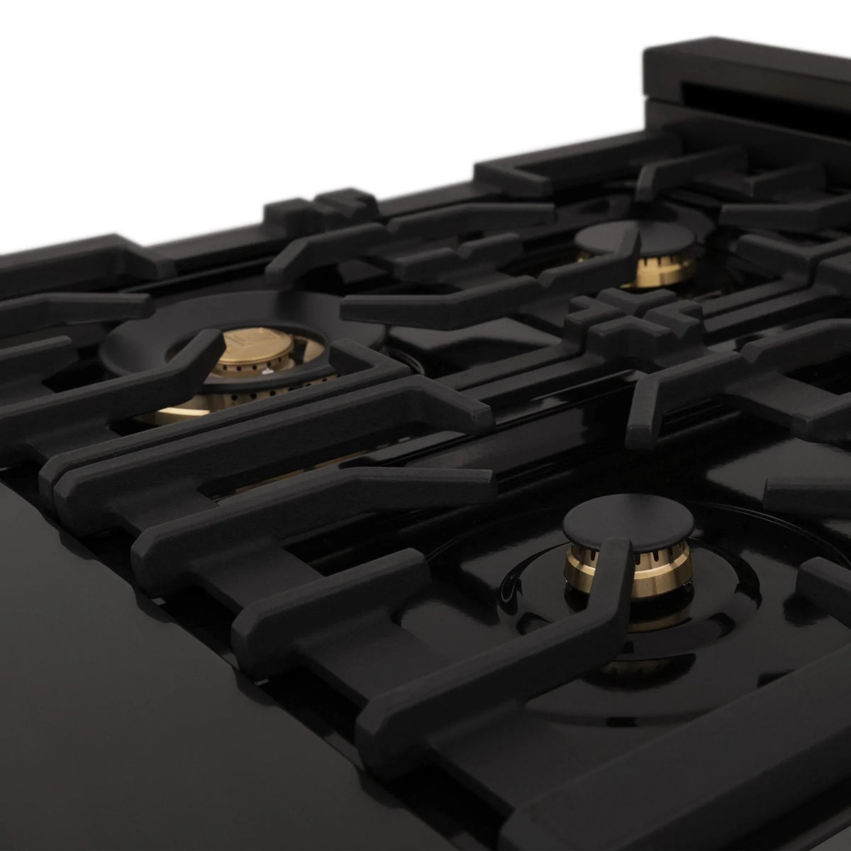 Black gas burner with gold center cap on dual fuel cooktop