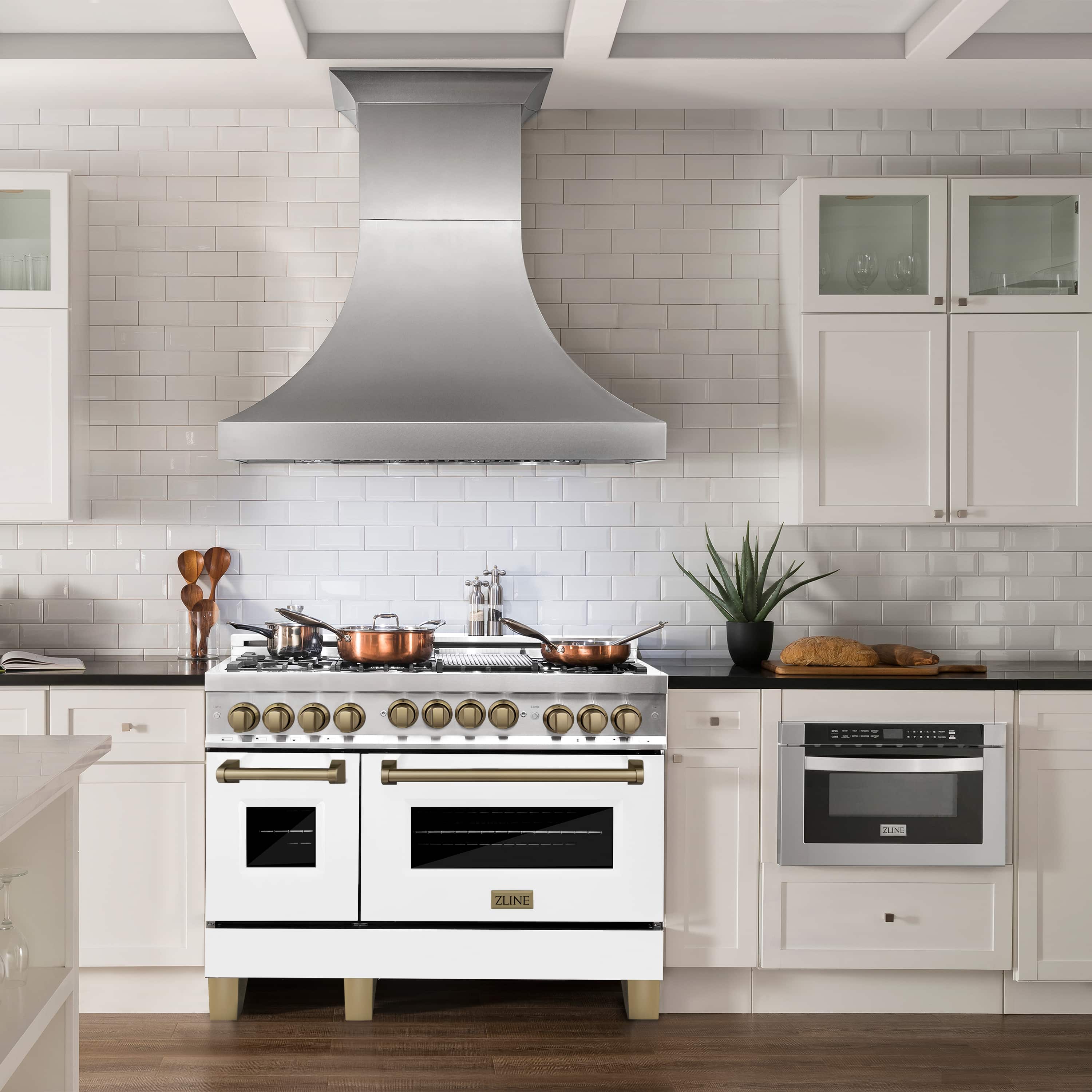 Stainless dual fuel range with white matte doors and champagne bronze knobs