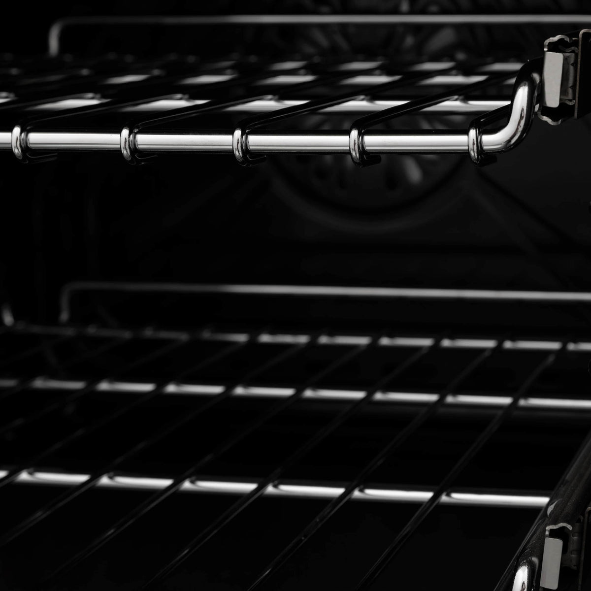 Chrome burner grate bars over black cooktop with gas burner housing