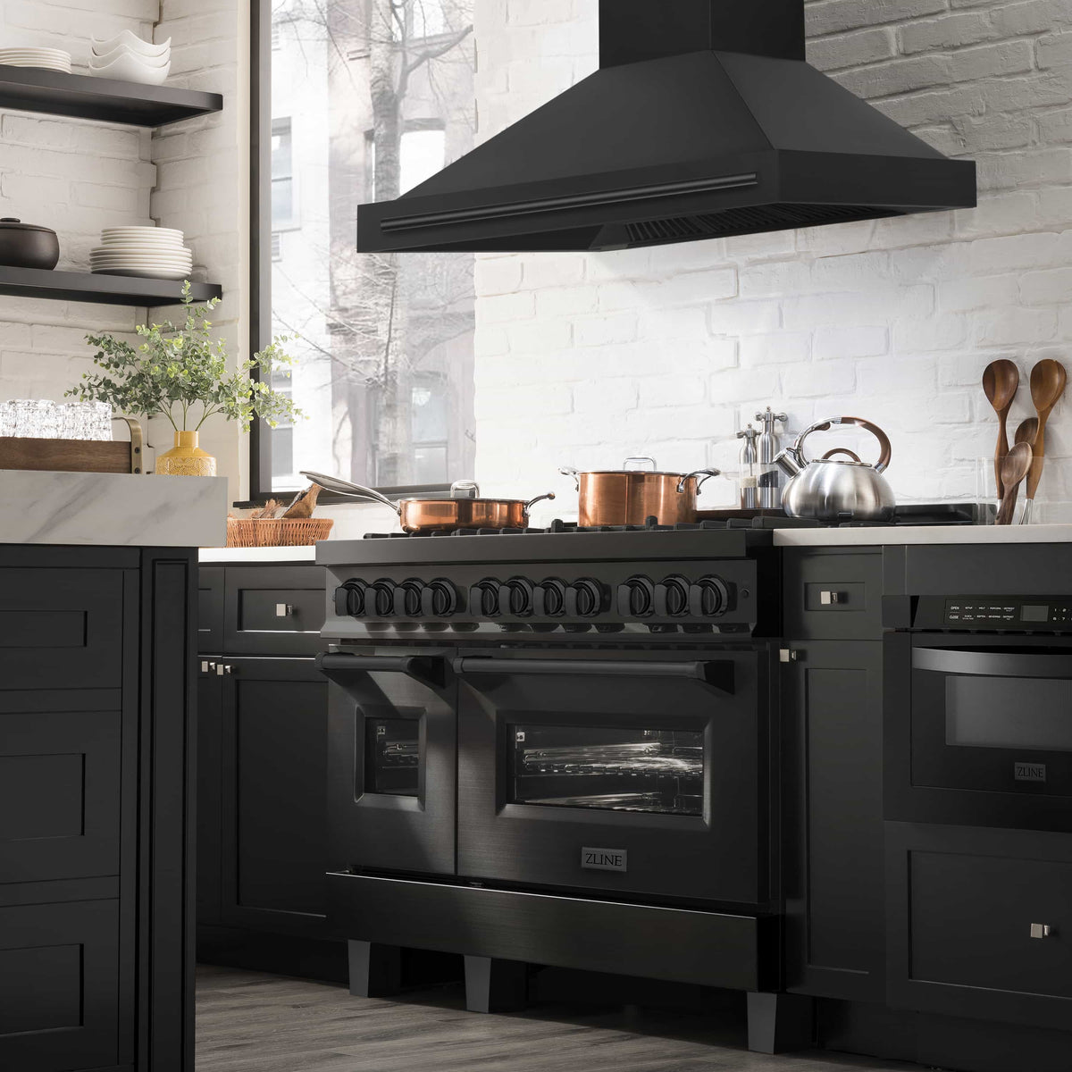 Black wall mount range hood above a gas range with vented underside