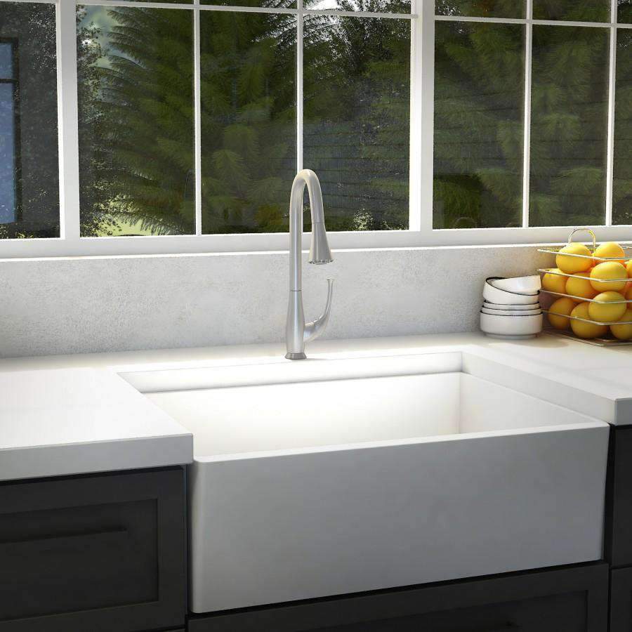 Brushed nickel kitchen faucet with tall curved spout above sink