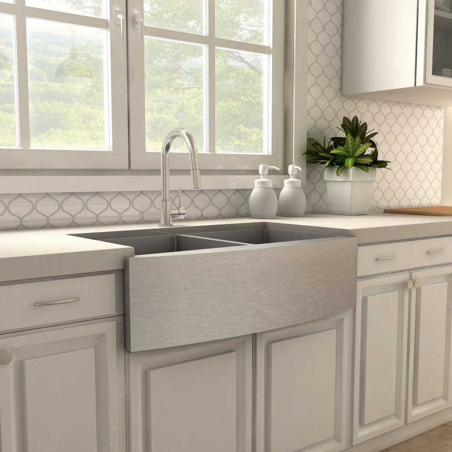 Brushed nickel kitchen faucet over double basin sink with curved spout