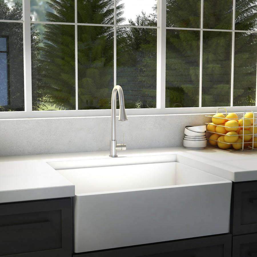 Brushed nickel kitchen faucet over sink with tall arched spout and handles
