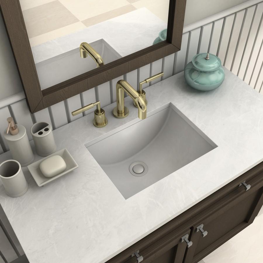 Polished gold bath faucet with arched spout over rectangular sink basin