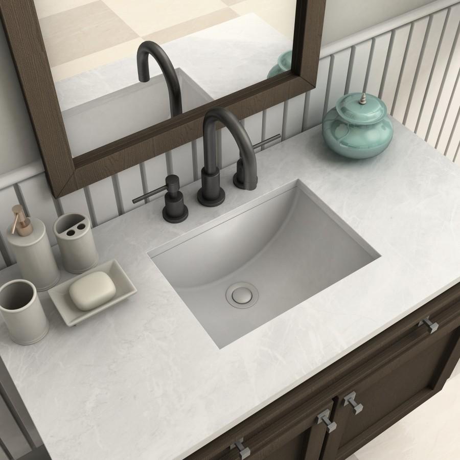 Matte black bath faucet with curved spout and two handles above rectangular sink