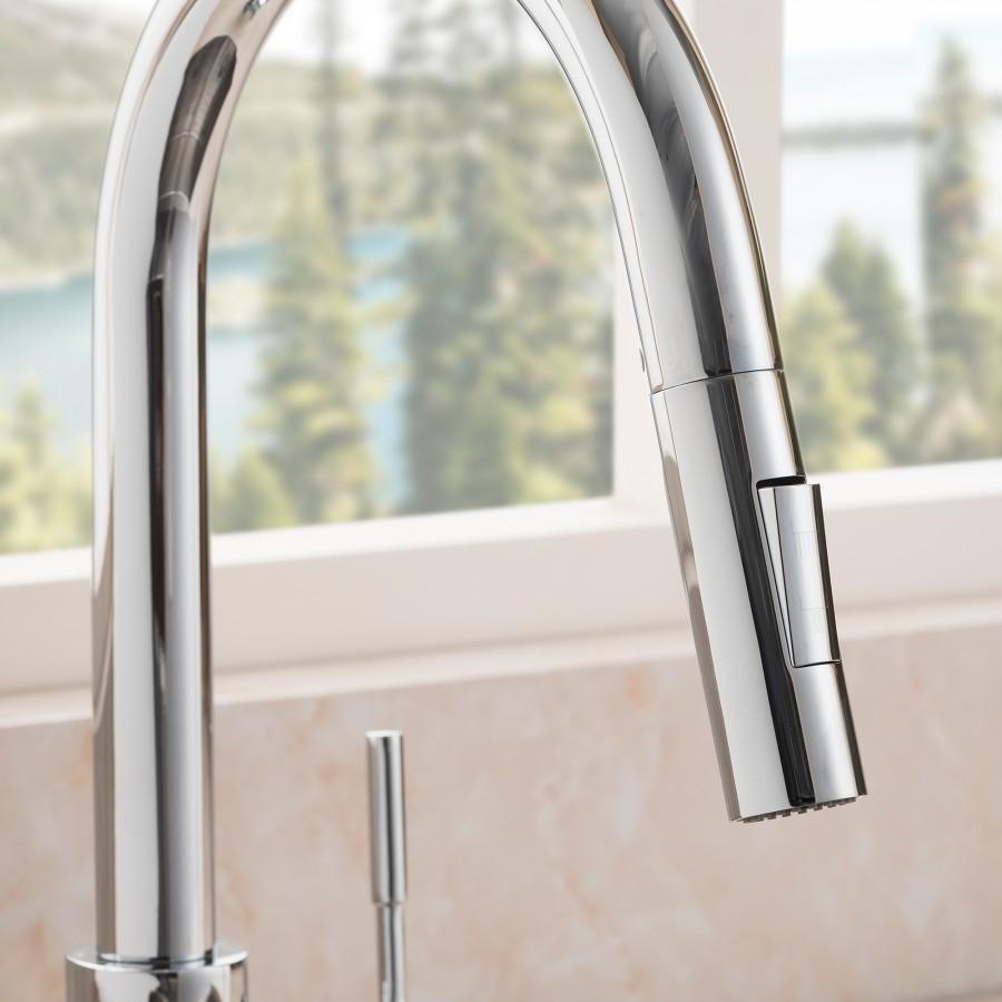 Close-up of chrome faucet spout with smooth cylindrical body and side lever