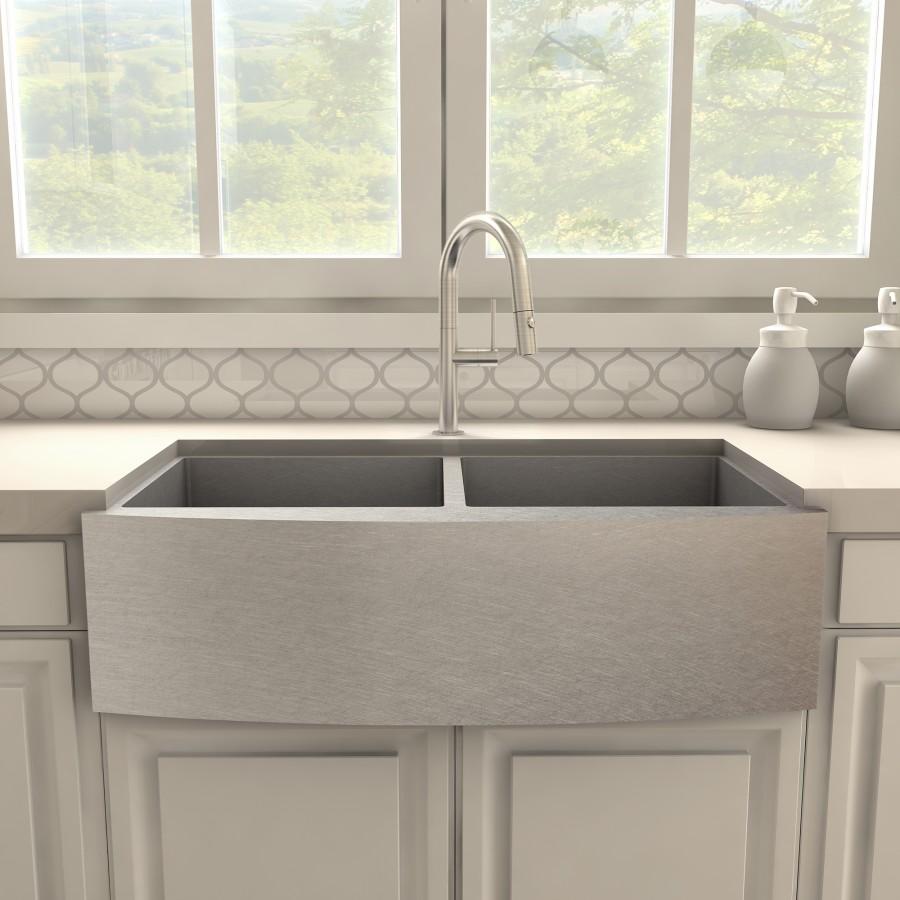 Brushed nickel kitchen faucet over a gray double-basin farmhouse sink
