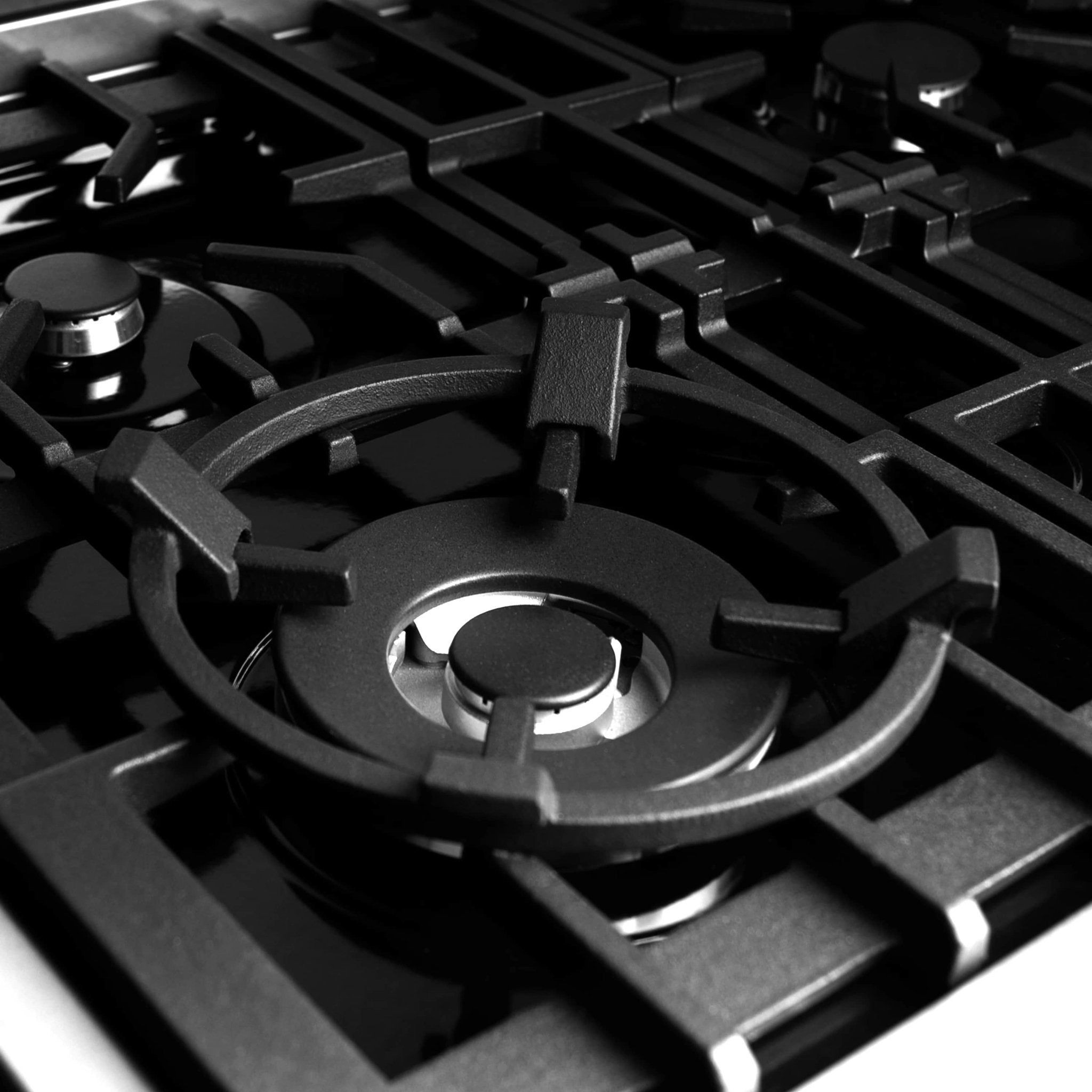 Black wok ring seated on a gas cooktop grate, shown in close-up