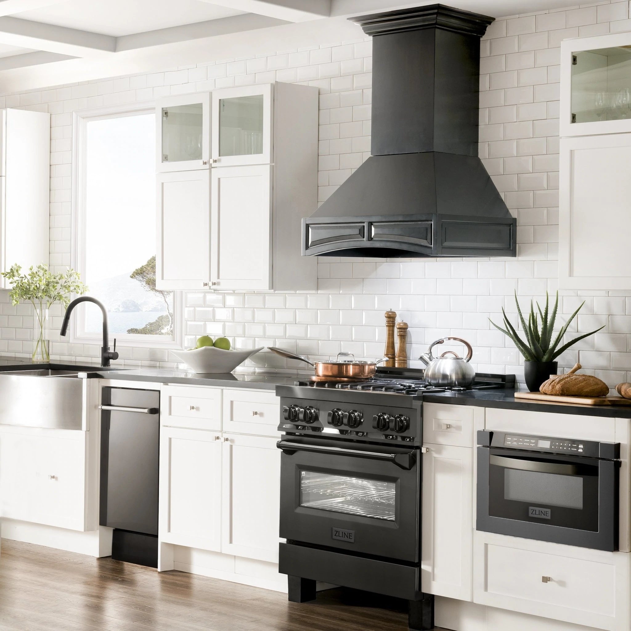 Black chimney wall-mounted range hood with vent grille in a bright white kitchen