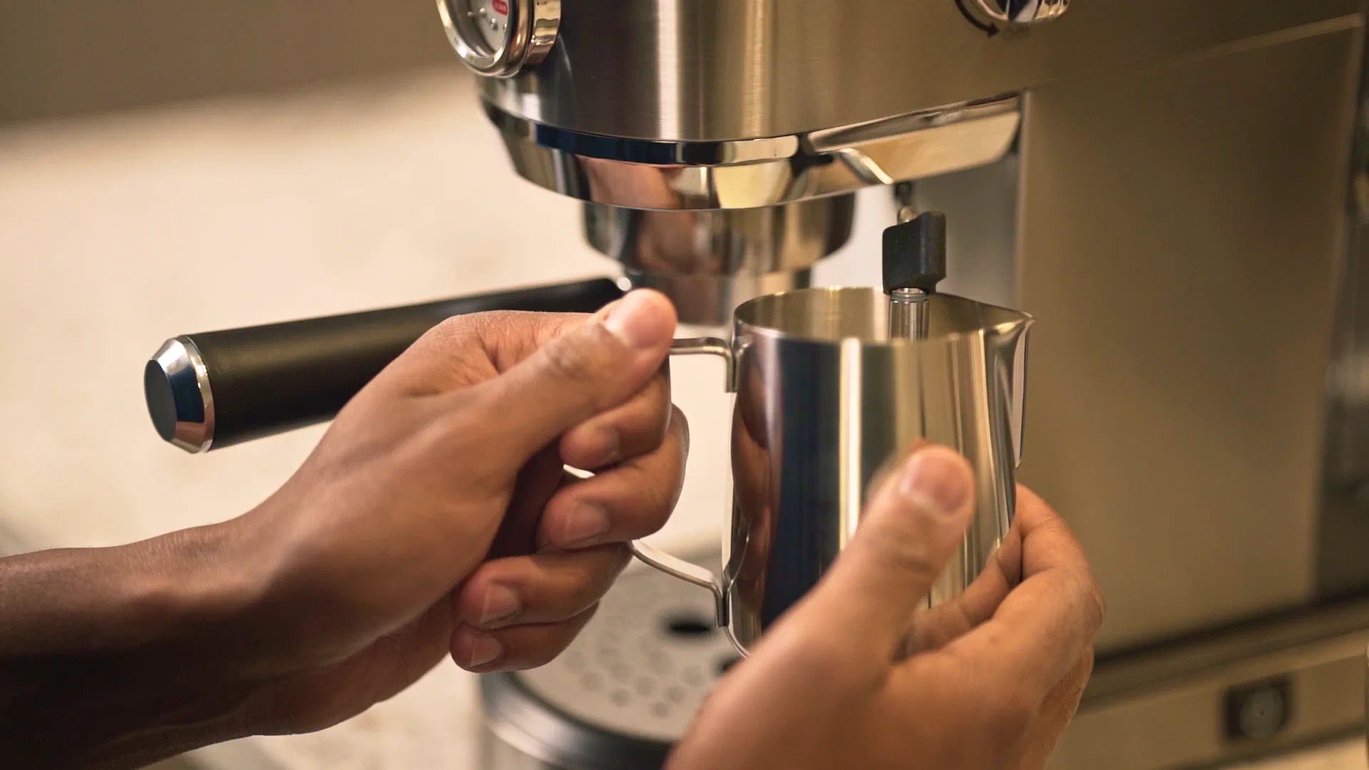 Portafilter being positioned against the espresso machine with metal drip tray