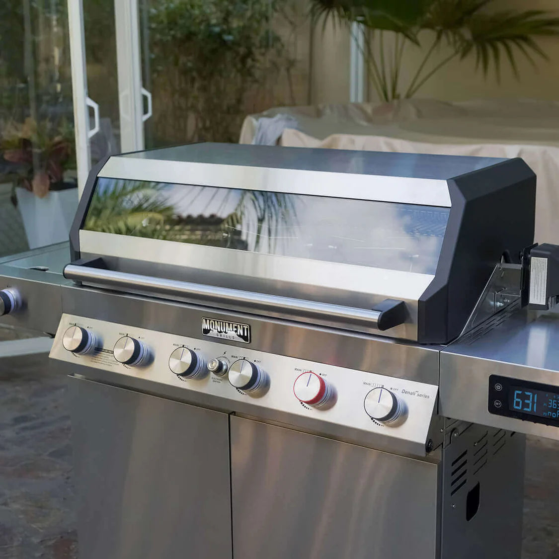 Stainless smart propane gas grill with open hood, burner knobs, and temperature display