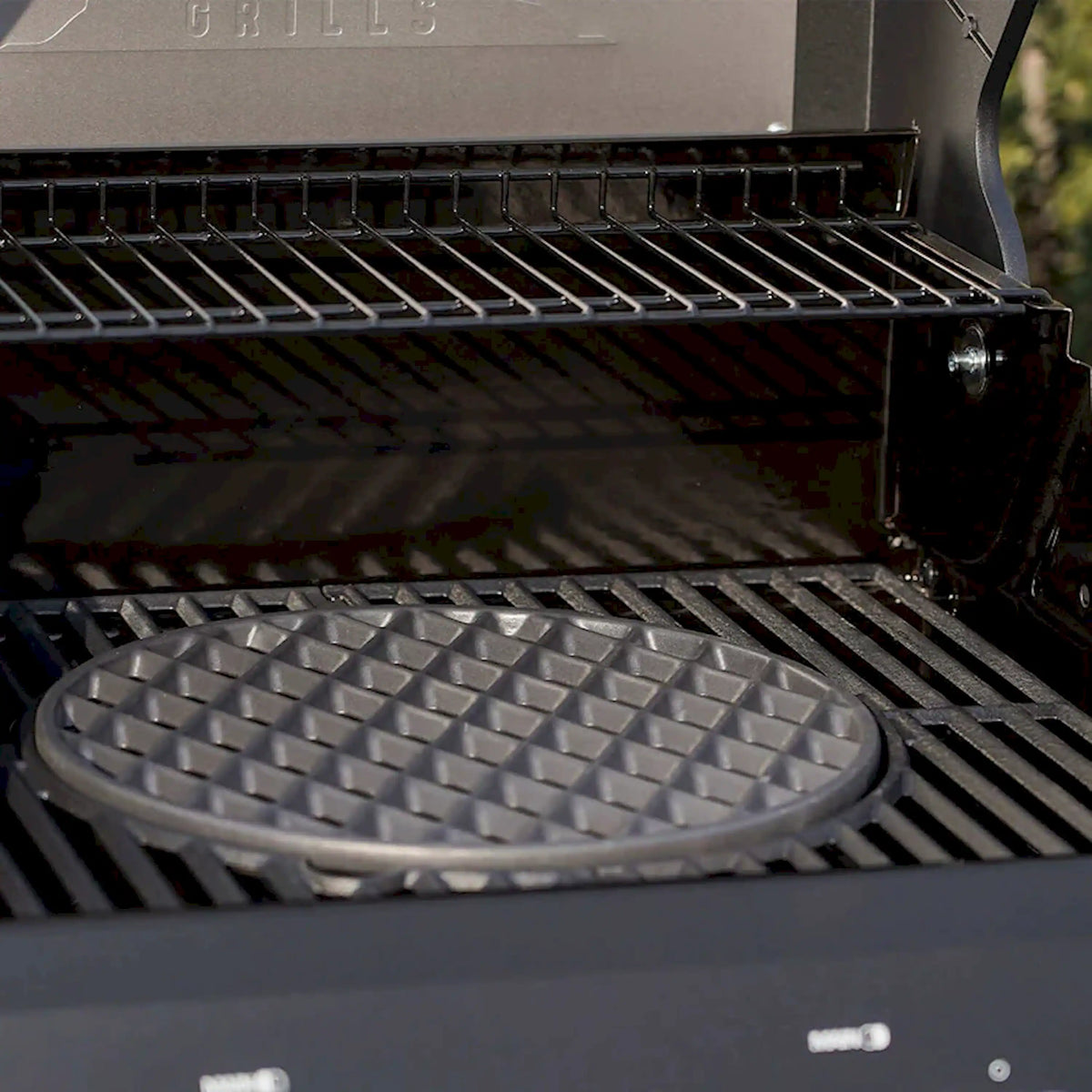 Circular black cast iron grill grate insert with raised checker texture