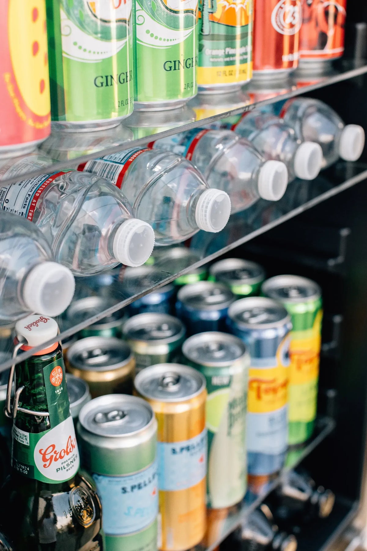 Outdoor beverage fridge with glass racks holding assorted cans and bottles