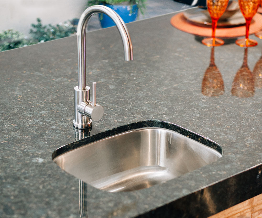 Stainless steel undermount kitchen sink with curved faucet spout