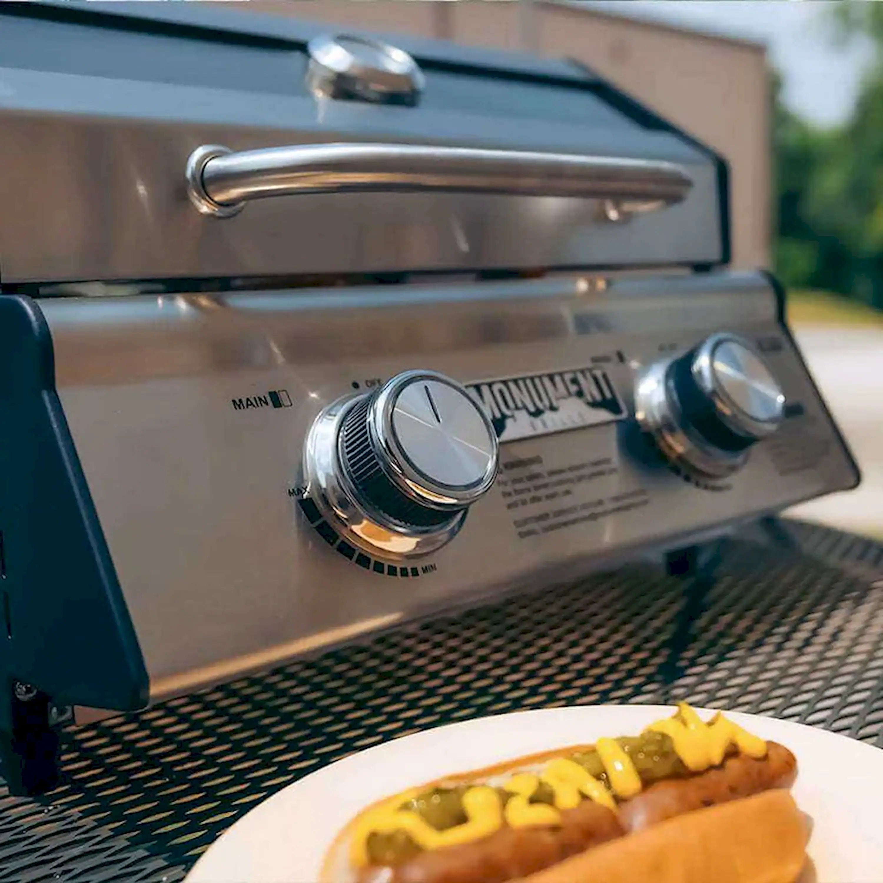 Stainless steel tabletop propane gas grill control panel with two knobs and logo