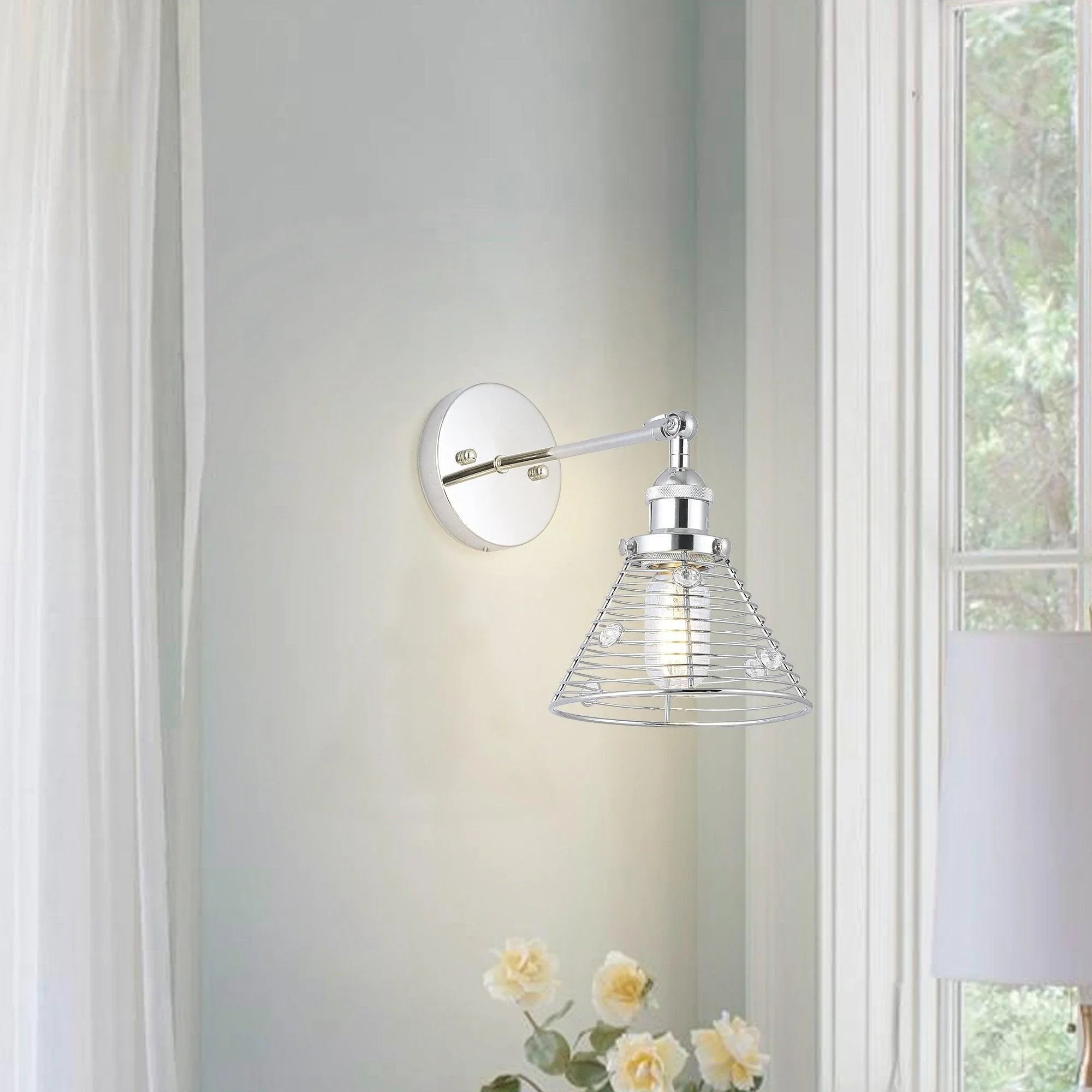 Silver wall sconce with round backplate and wire cage shade for 1 bulb
