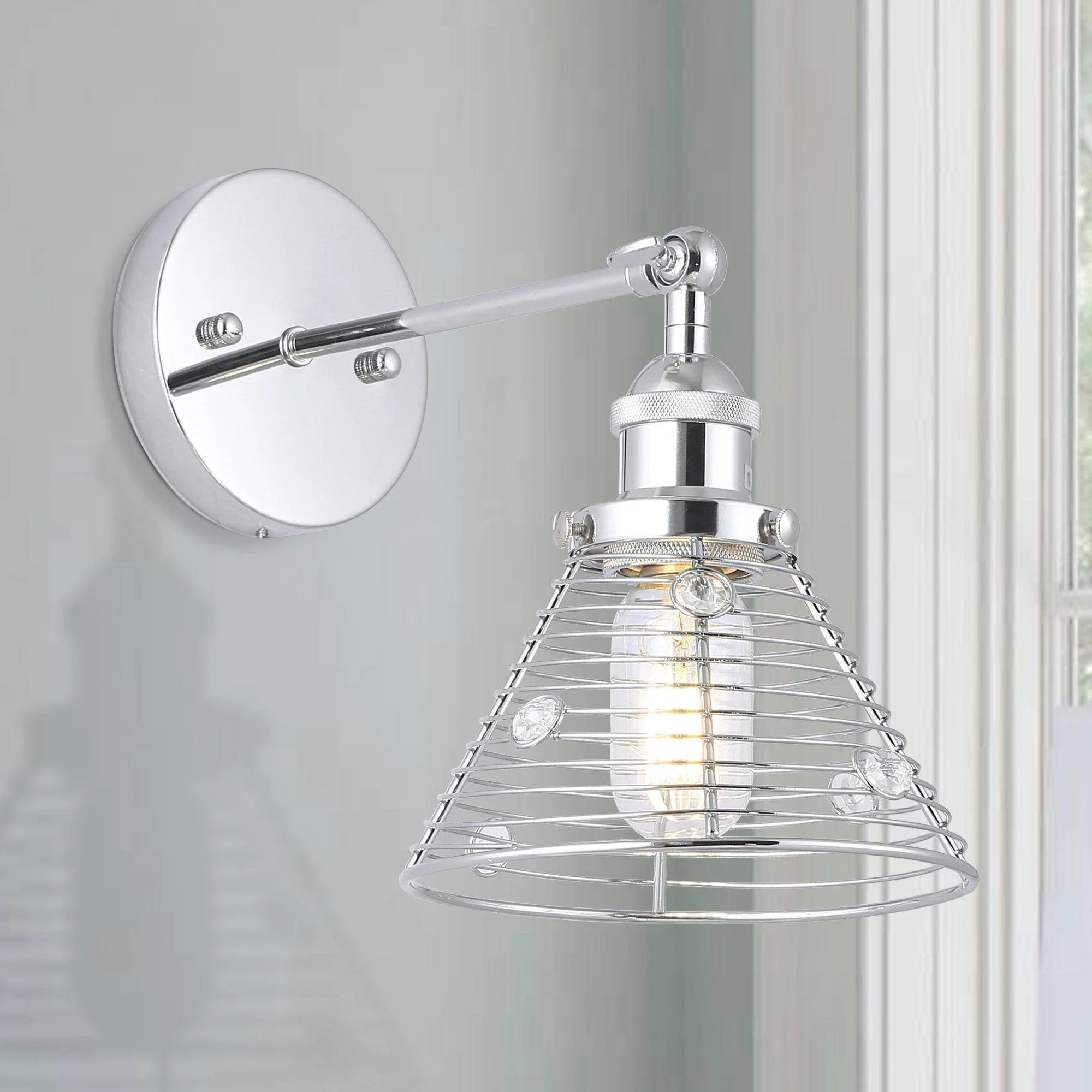 Silver wall sconce on round plate with long arm and metal wire cage lamp shade