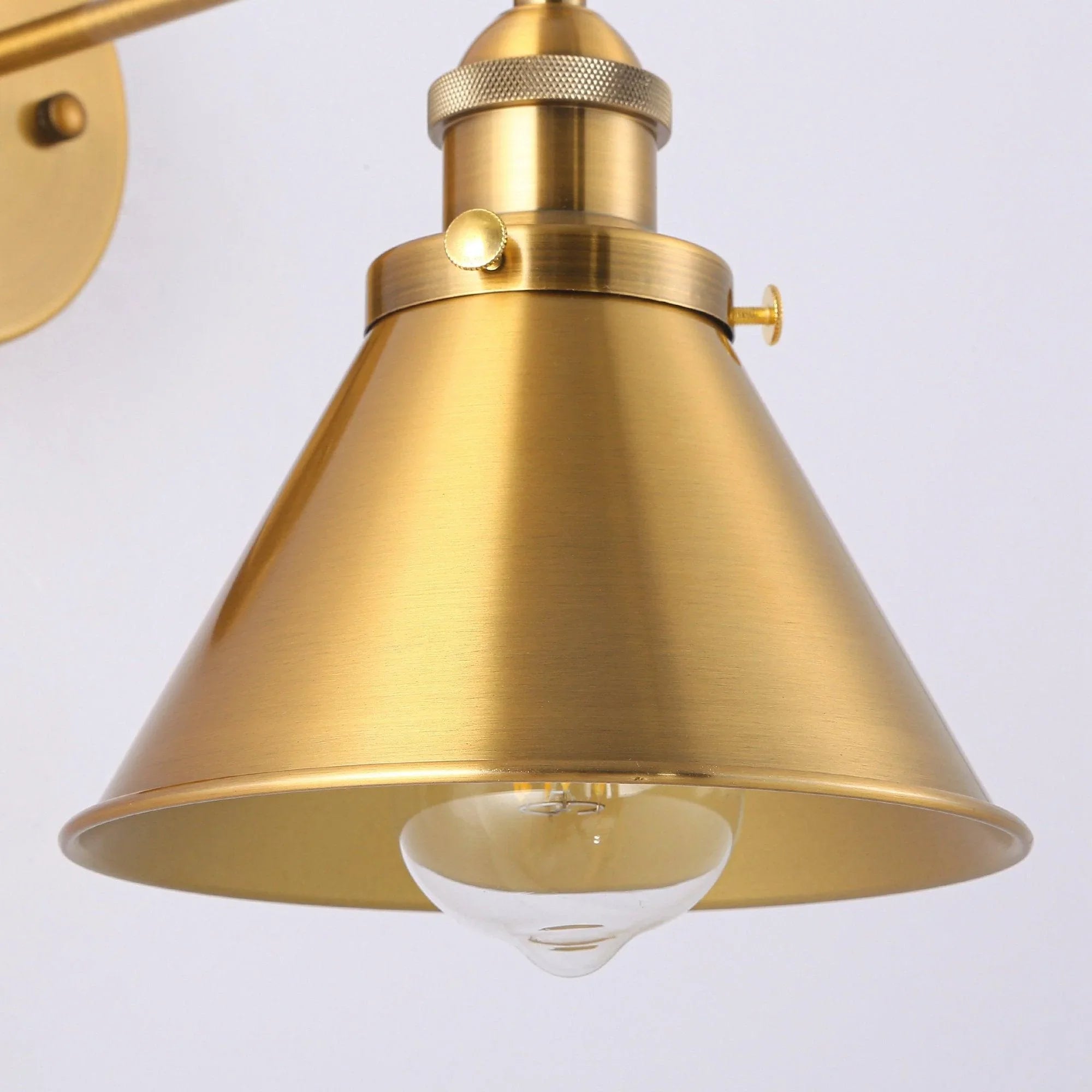 Golden brass bell shade with exposed bulb and ribbed collar above the shade