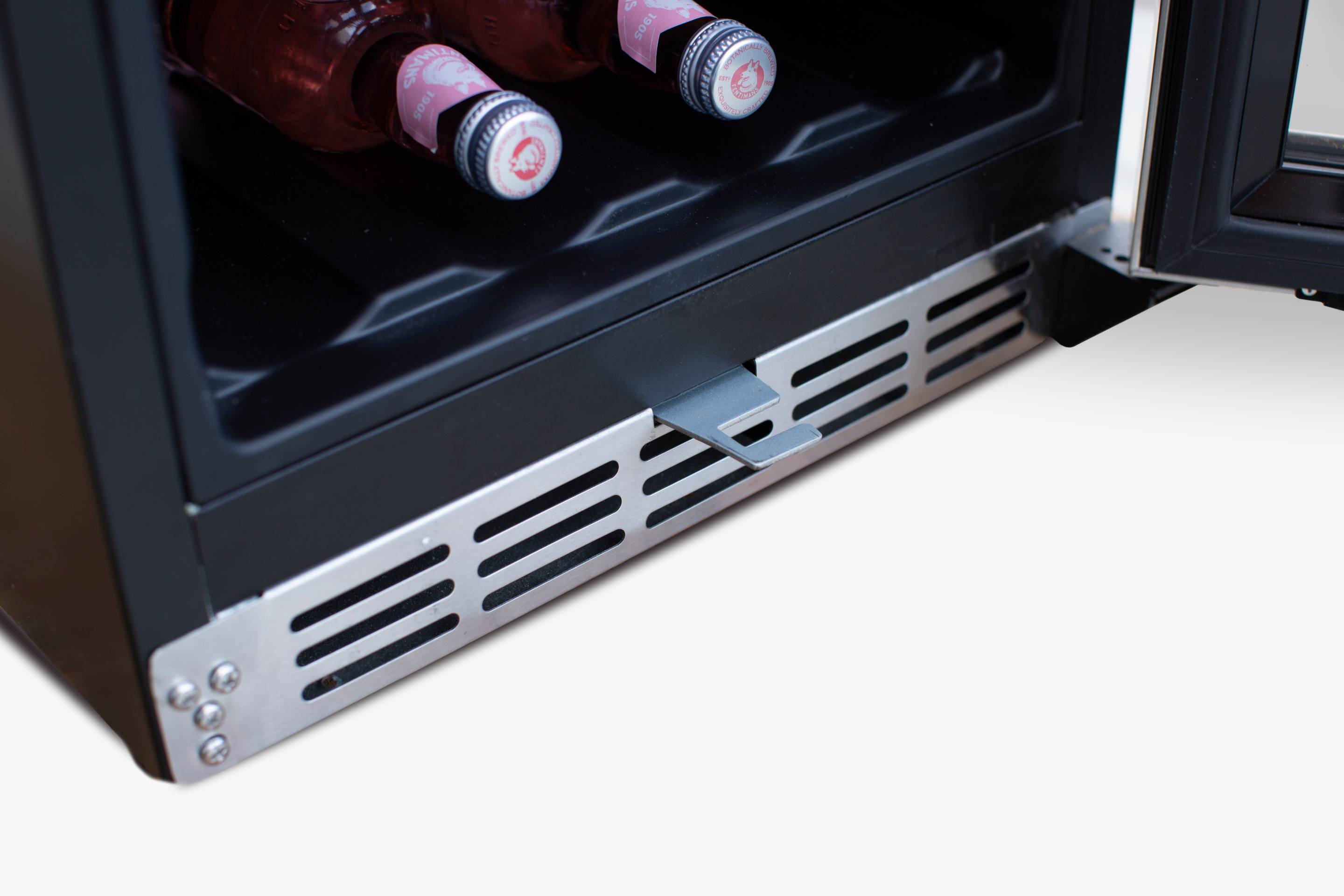 Outdoor wine cooler bottom vent with stainless grille and bottles in lower shelf