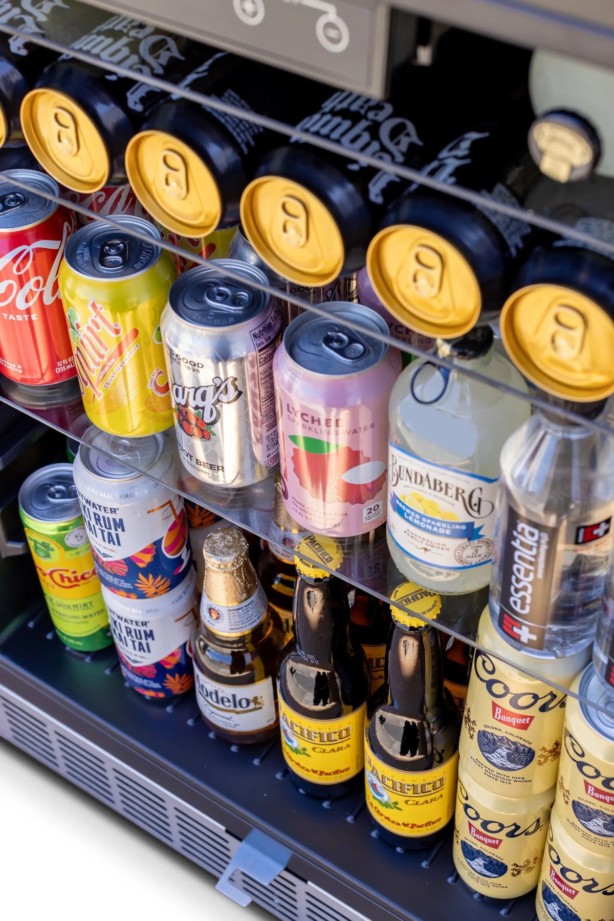 Outdoor-rated fridge interior shelf stocked with assorted drink cans in rows