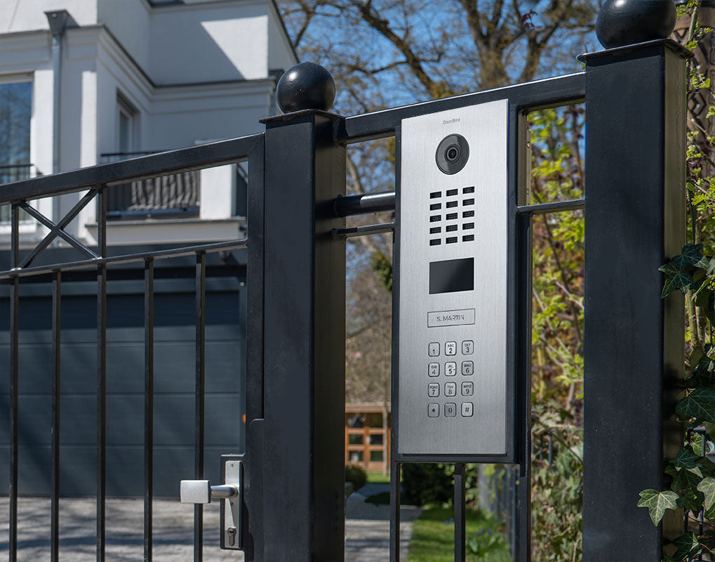 DoorBird slate grey outdoor intercom panel with camera, keypad, and call button