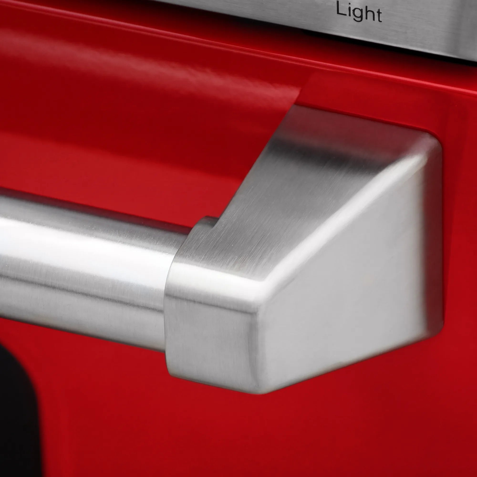 Stainless steel oven handle on red electric range door