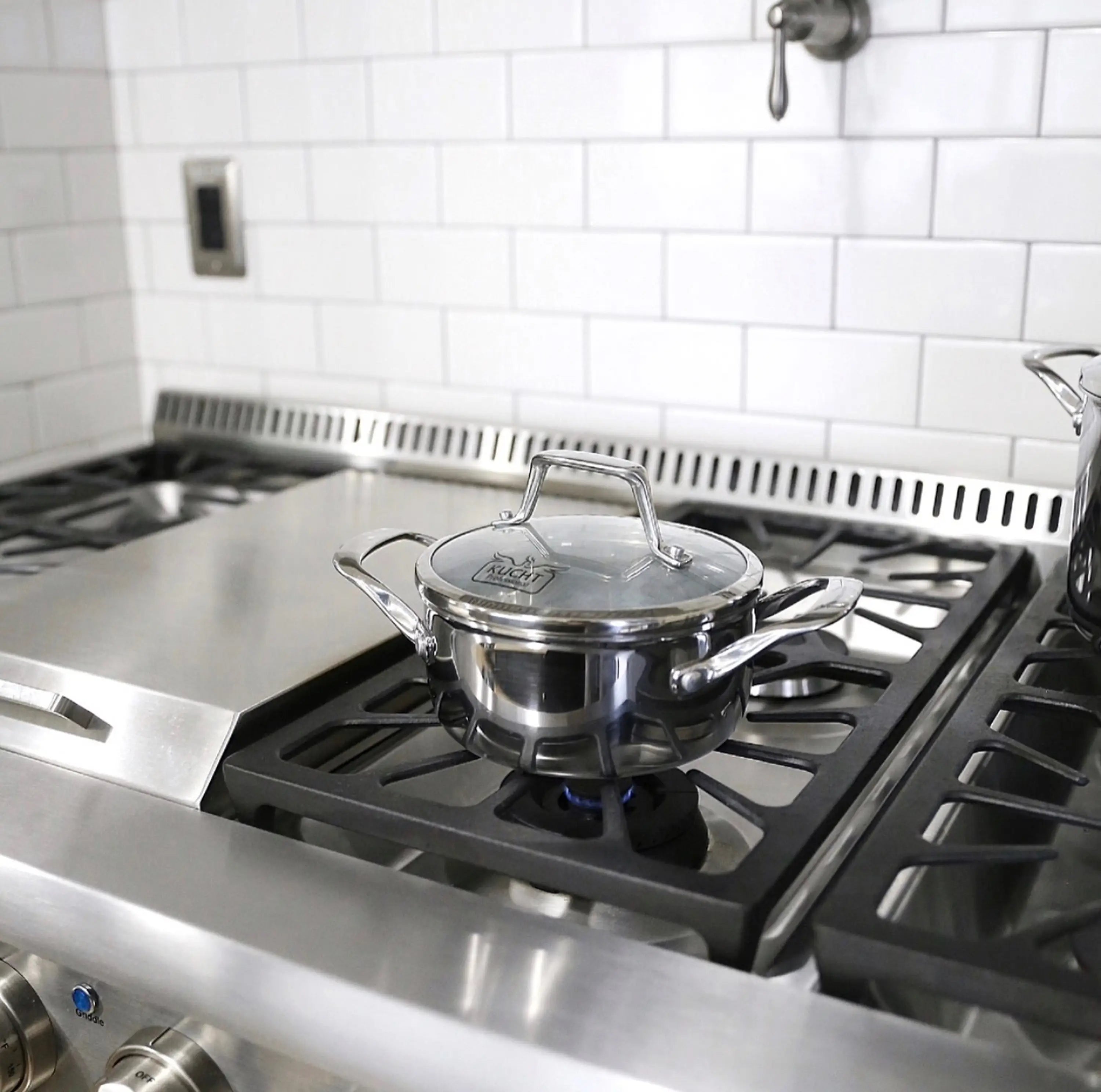 Stainless steel 3-ply saucepan with lid on gas cooktop burner