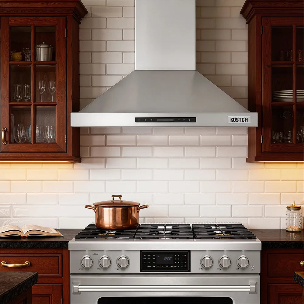 Stainless steel convertible wall-mounted range hood above a stainless kitchen cooktop
