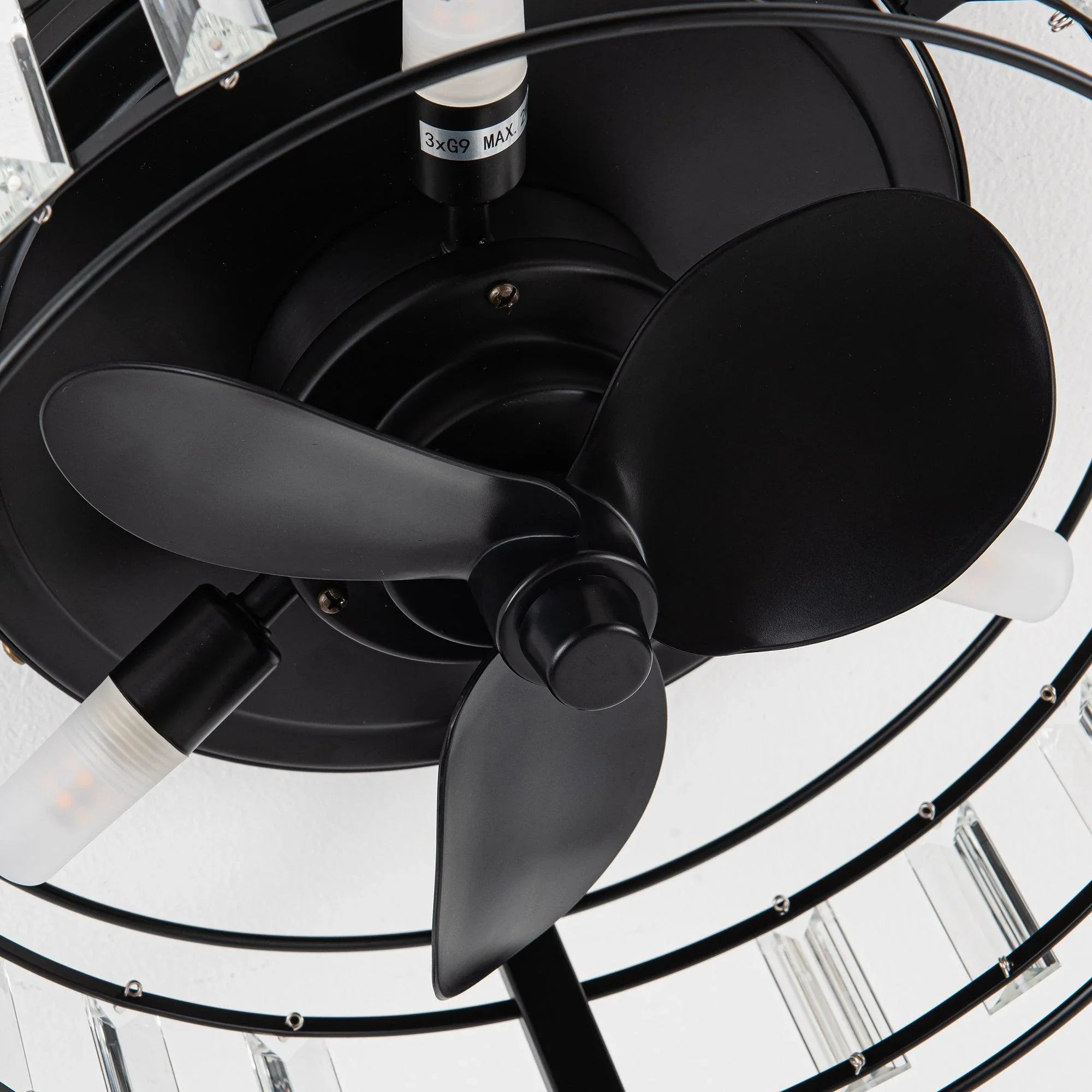Close-up of black ceiling fan blades and clear crystal ring on flush mount