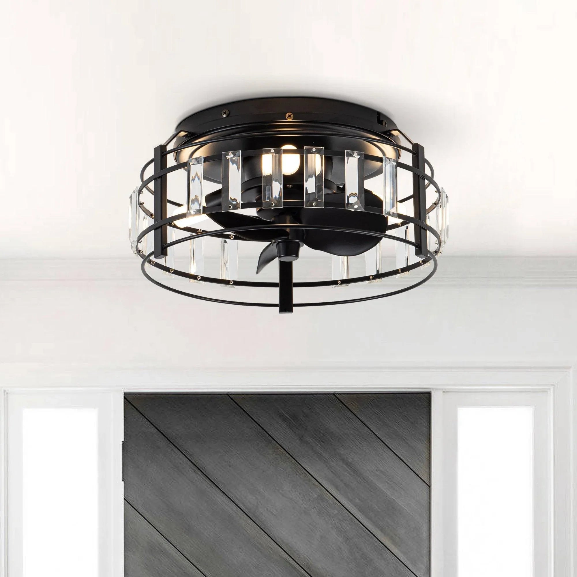 Black flush-mount ceiling fan with clear crystal panels and three illuminated bulbs