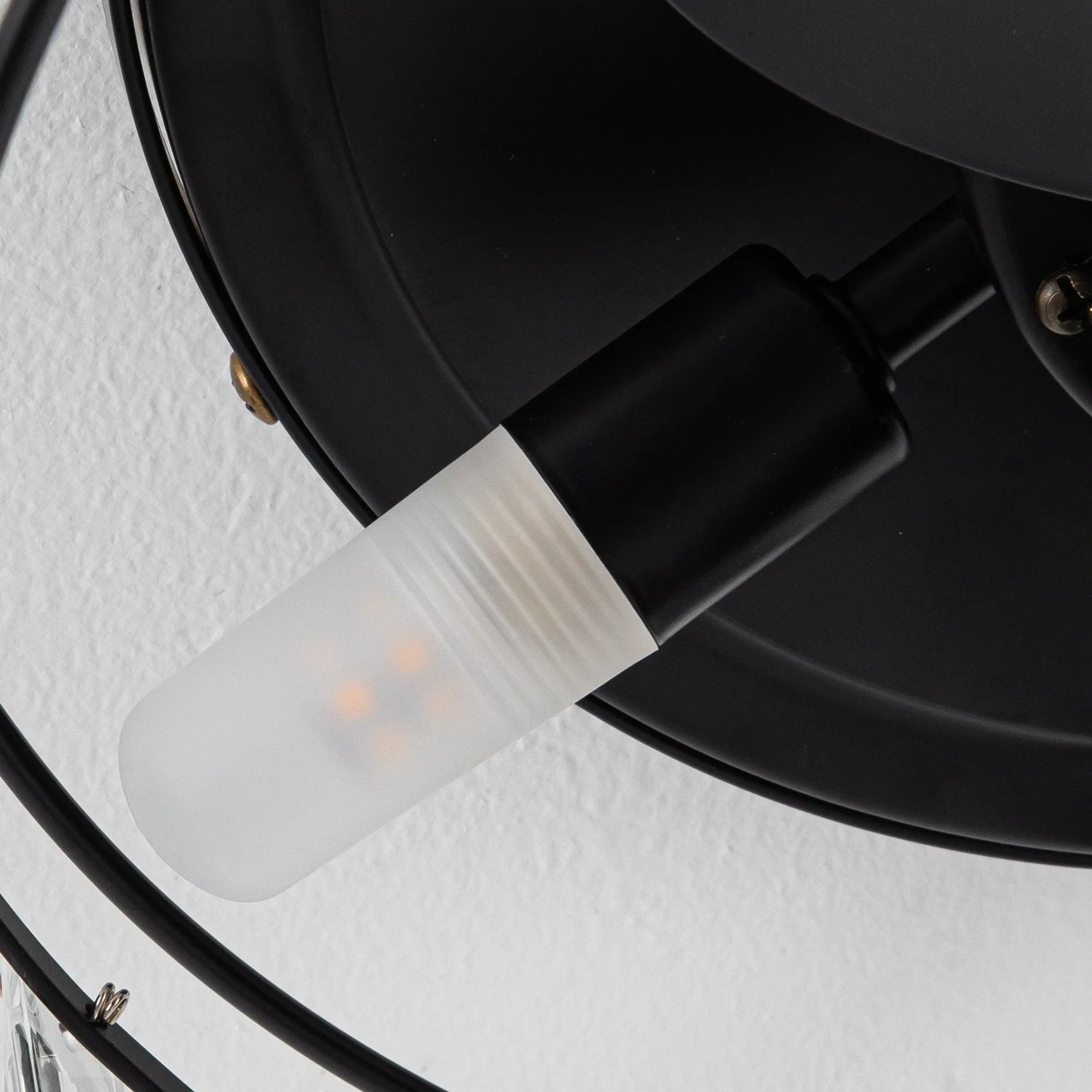 Close-up of black fan light with frosted glass bulb cover and frame