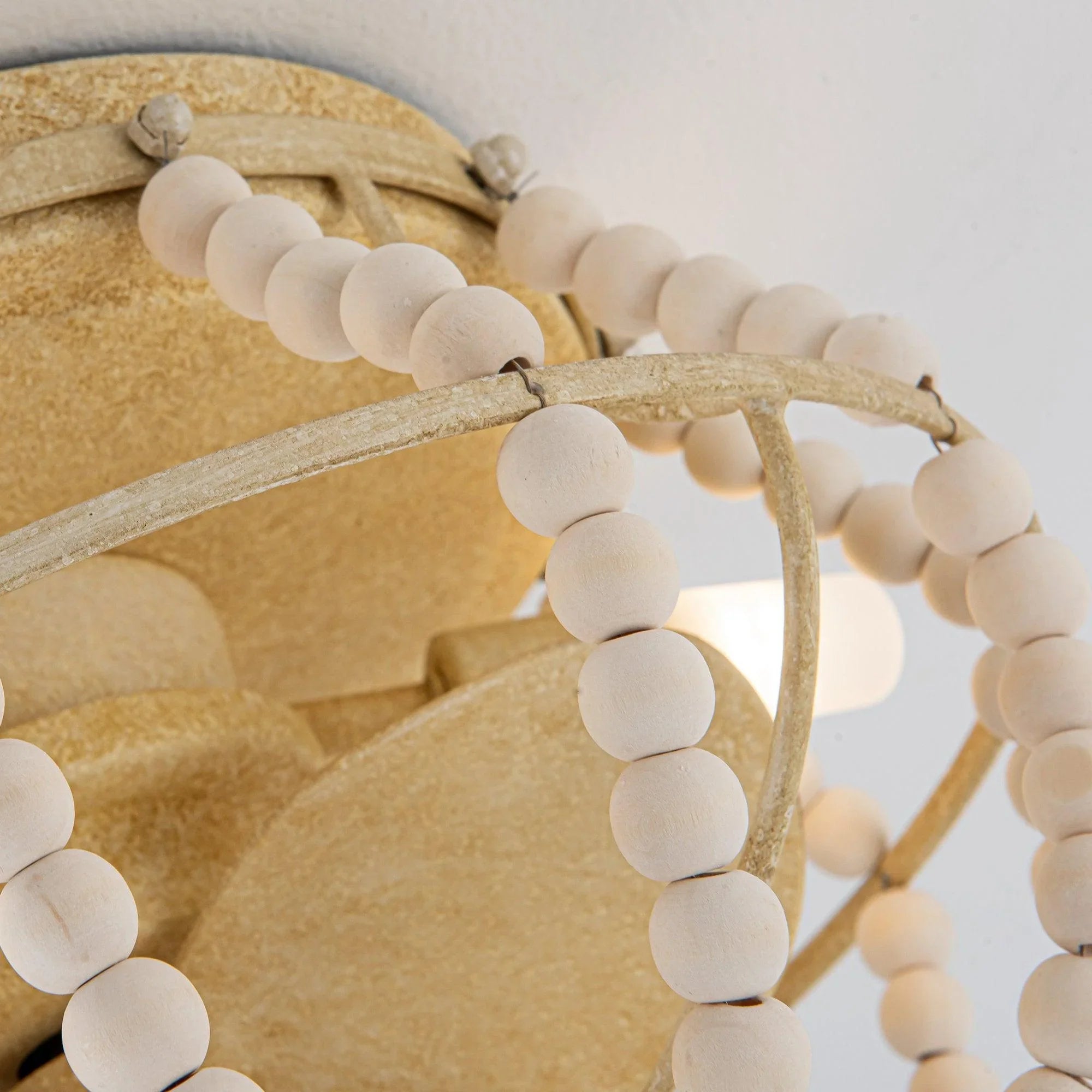 Close-up of beige flush mount fan motor housing with white beaded strand detail