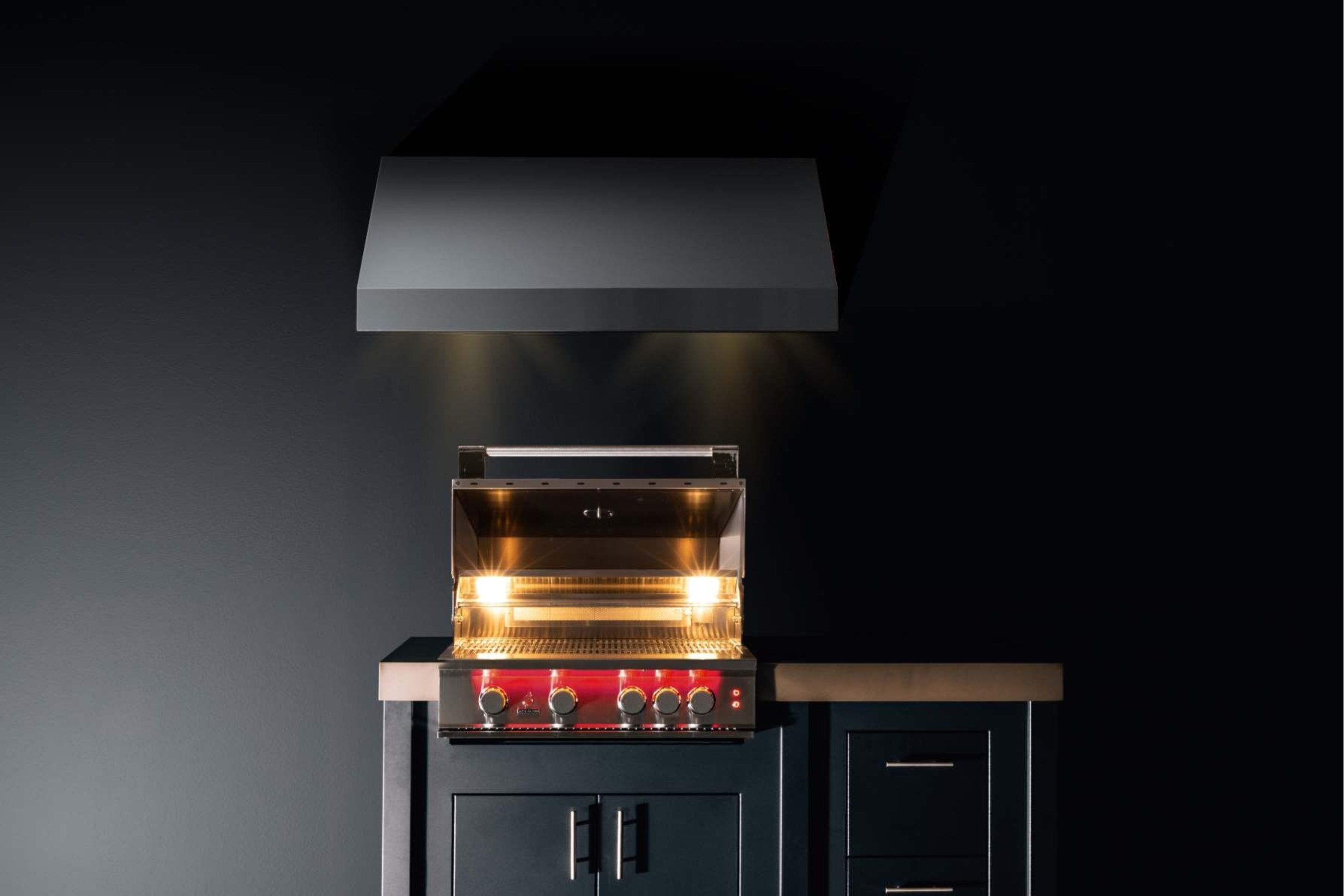 Stainless steel propane gas grill with open lid showing illuminated burners and control panel