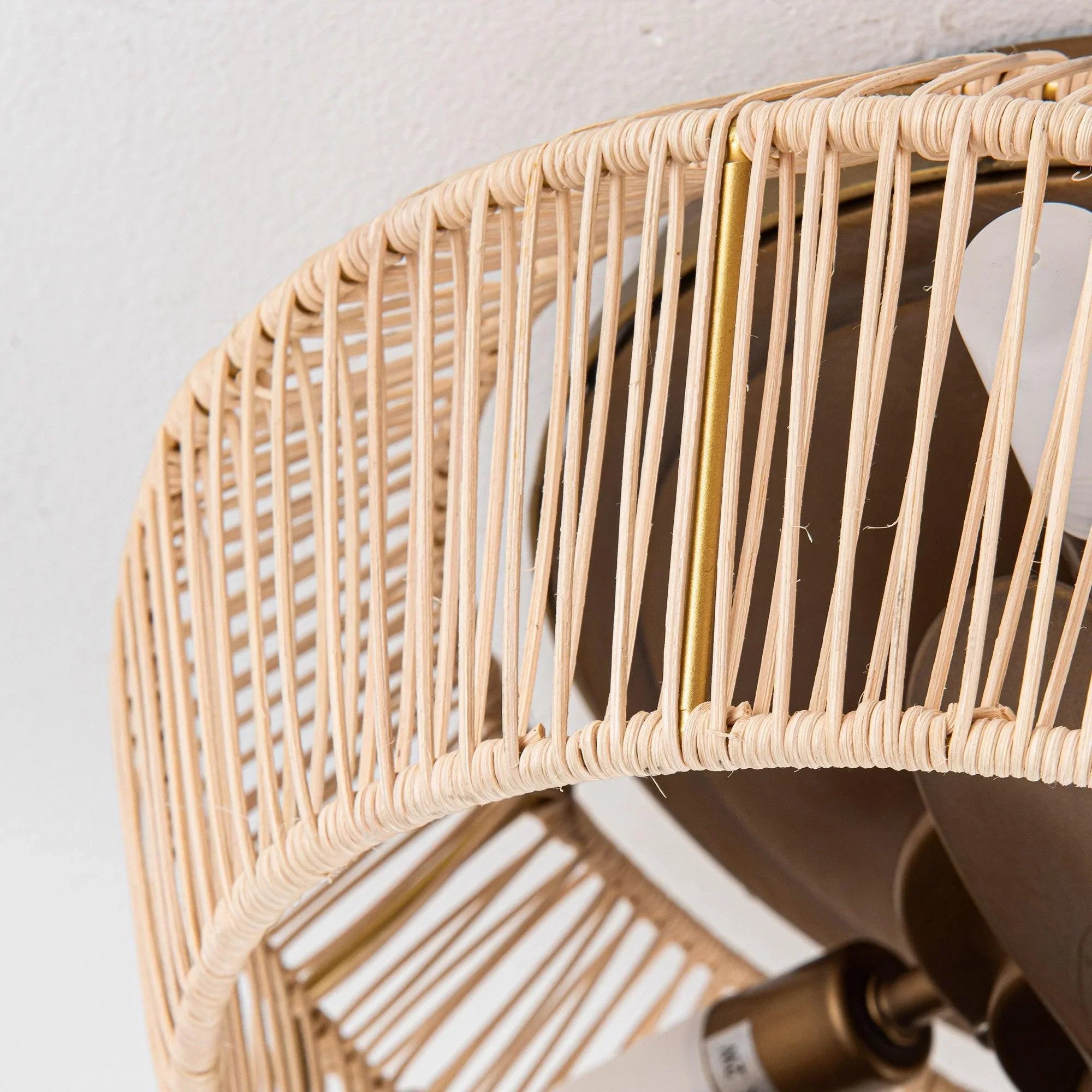 Golden rattan-style caged ceiling fan with visible blades and metal motor hub