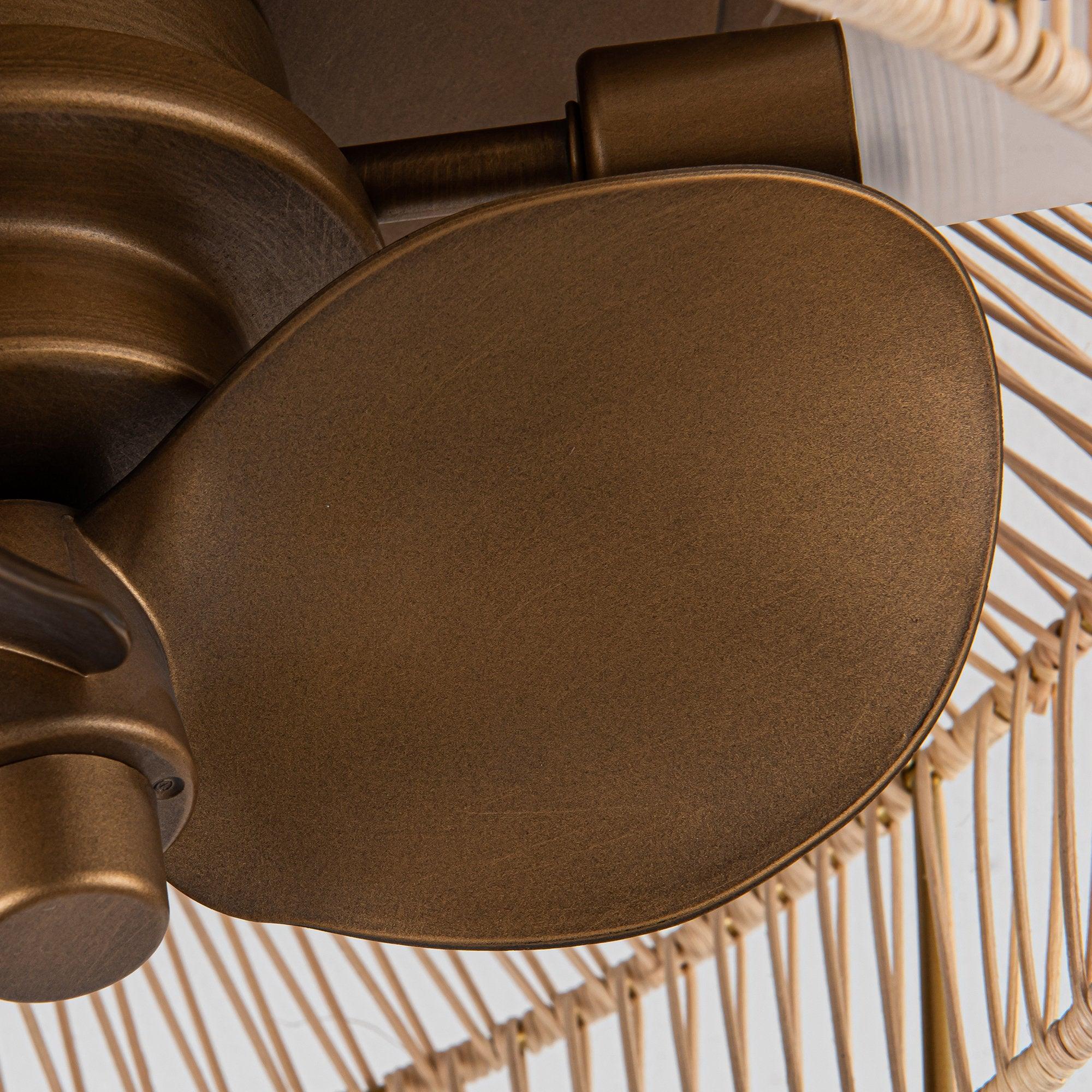 Golden ceiling fan blade and motor housing inside an open wicker-style cage