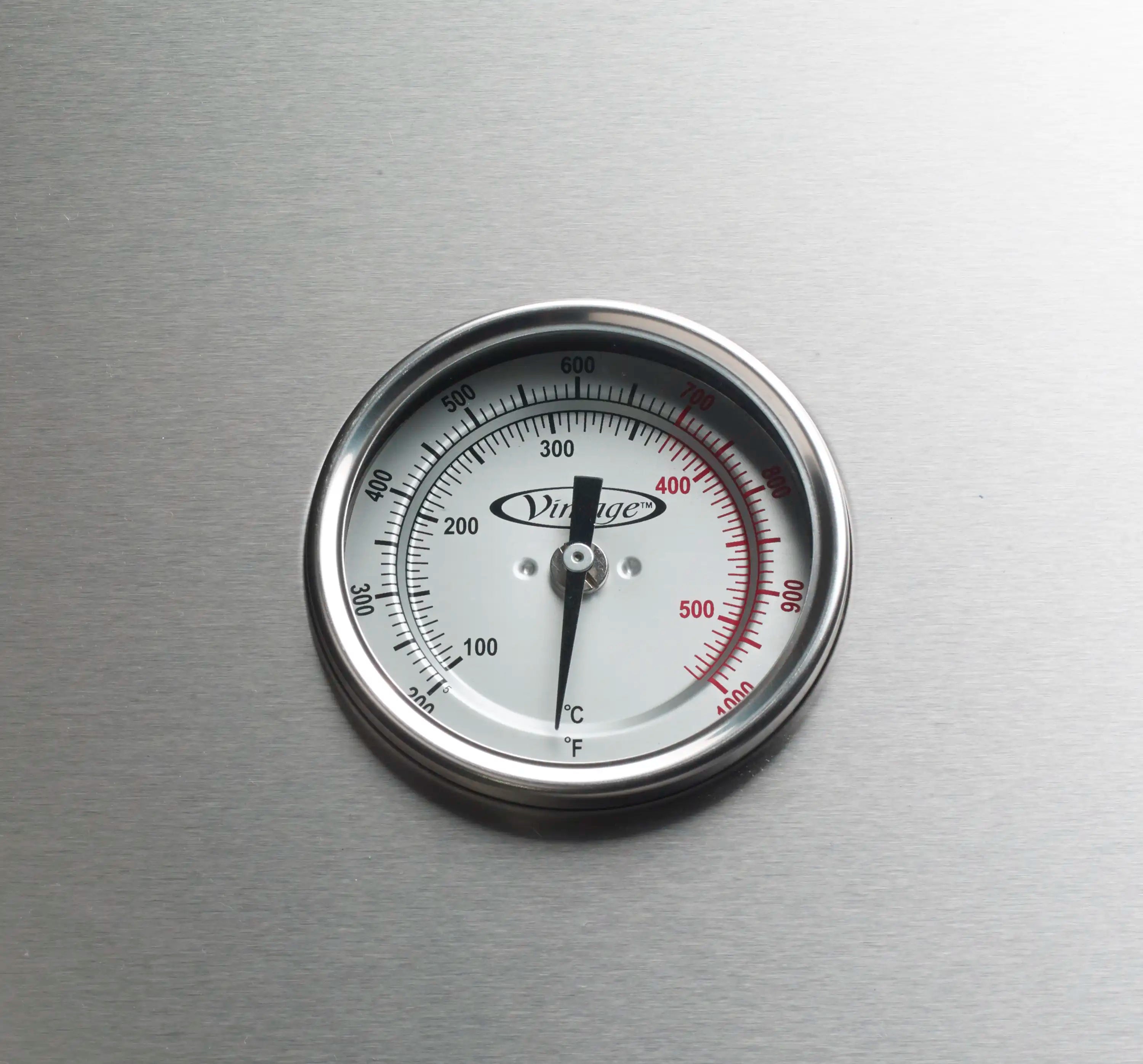 Round temperature gauge on stainless steel propane gas grill face