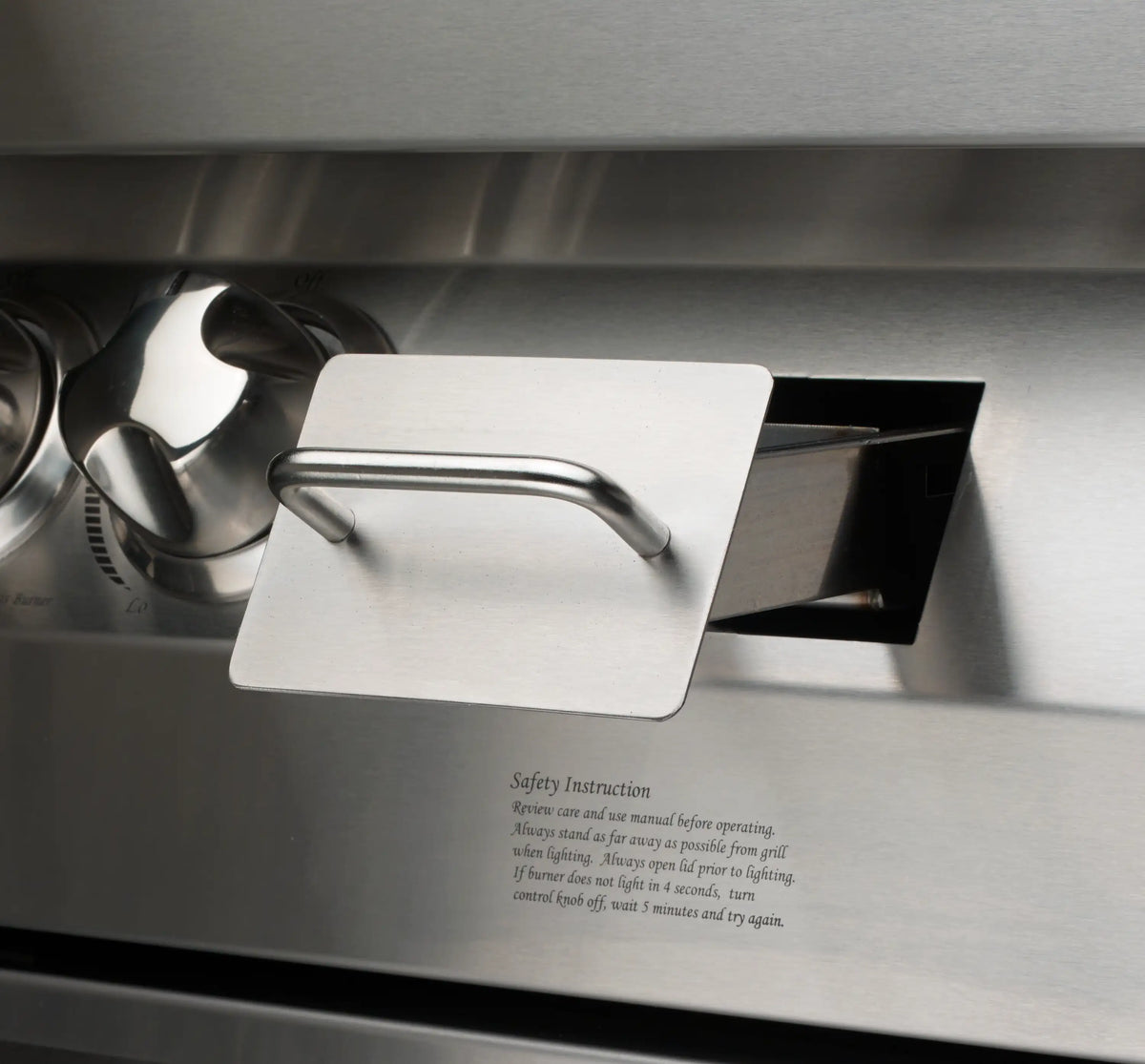 Stainless steel grill lid handle with safety instruction label on front panel