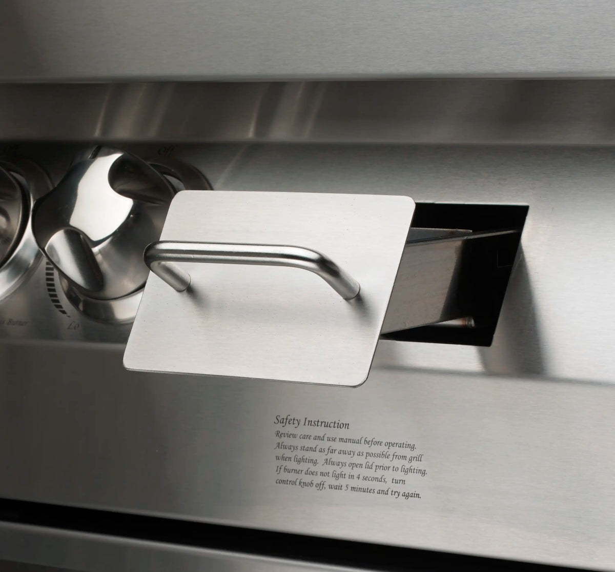 Stainless grill side panel with latch cover and safety instruction text